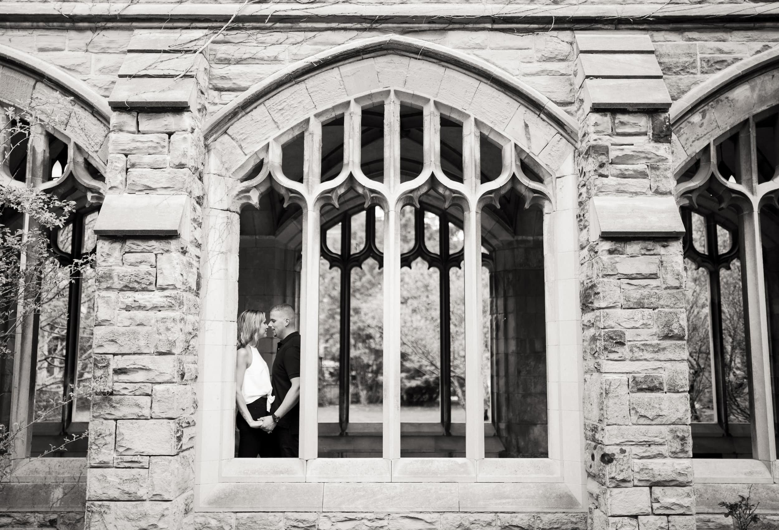 Black and white portrait framed by Gothic window at Knox College, University of Toronto in Toronto, Ontario