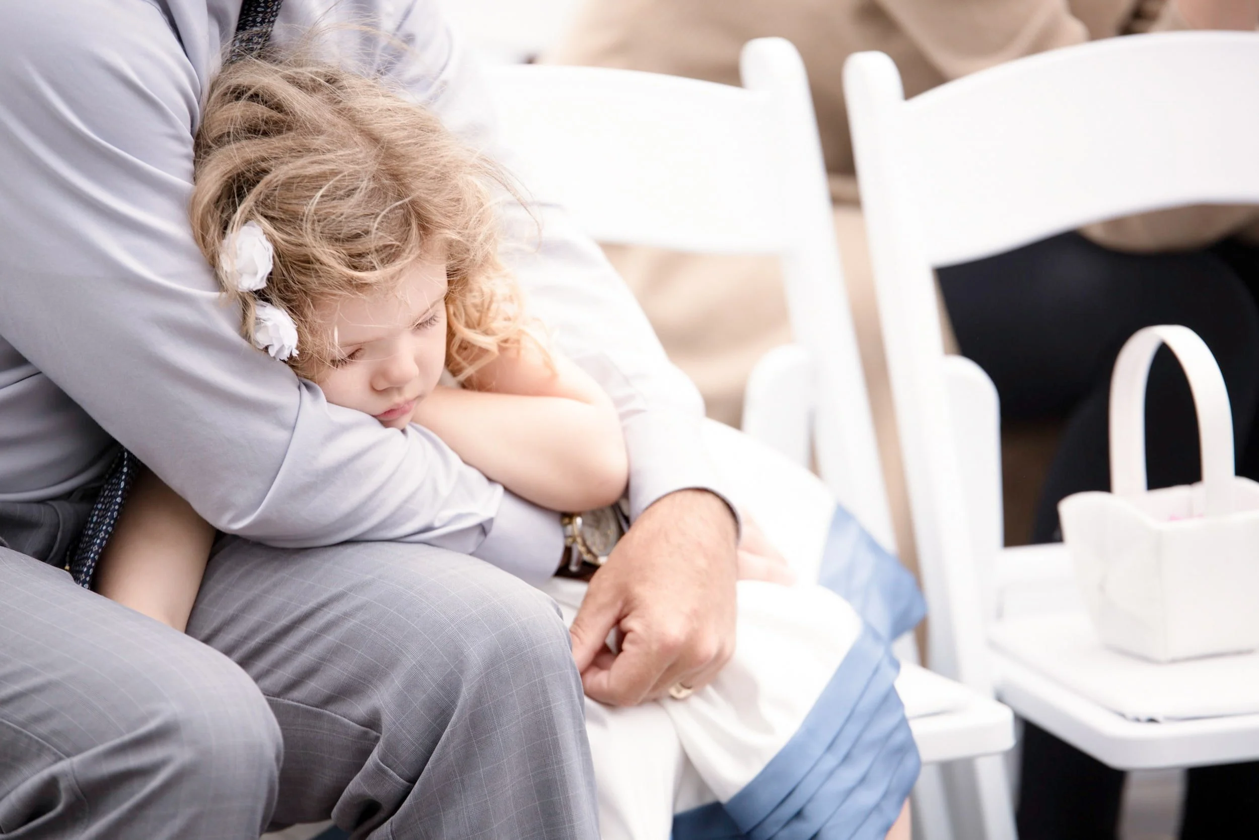 Candid moment of sleeping flower girl during the Arlington Estate wedding ceremony in Vaughan