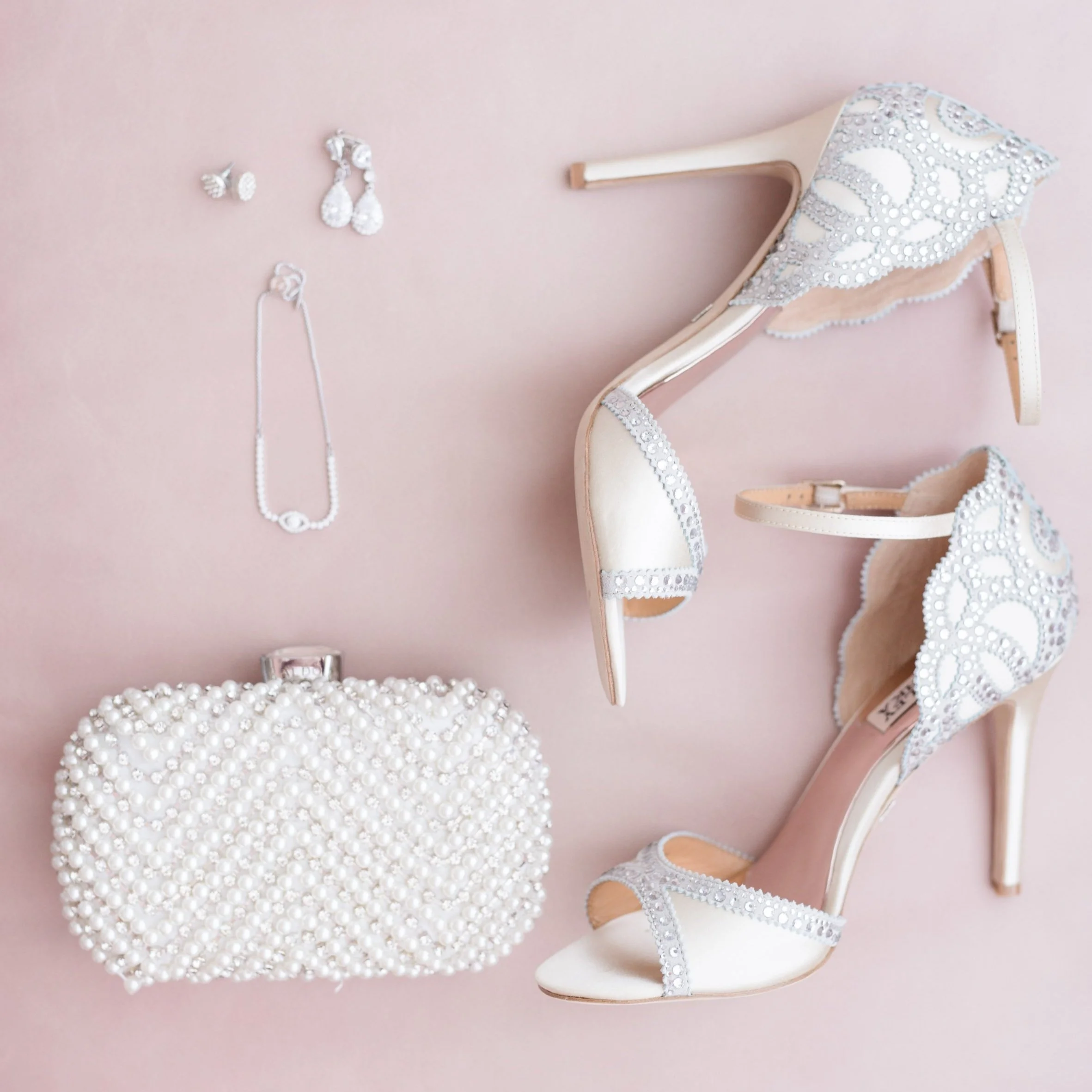 Flat lay of a bride’s heels and wedding details on a pink mat at Hotel X in Toronto, Ontario