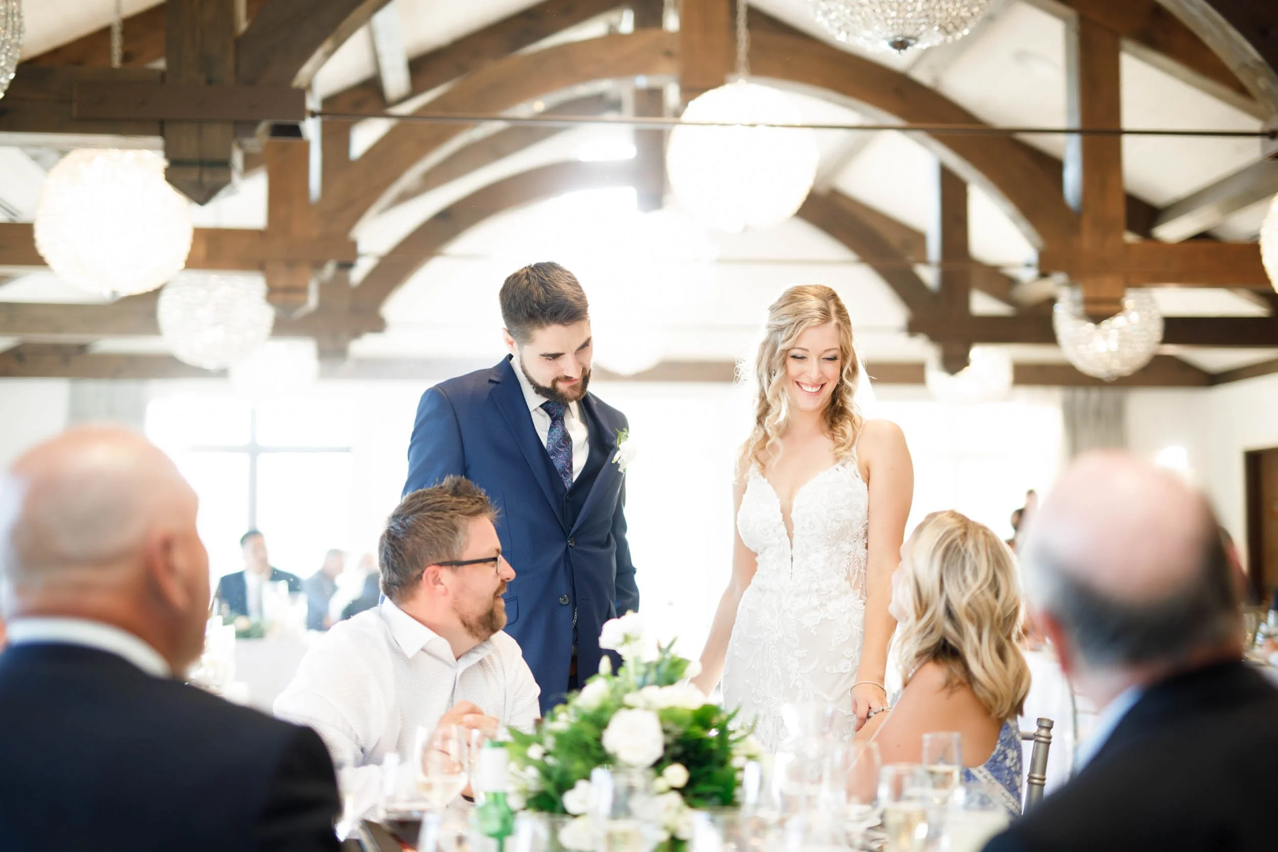Reception moment inside timber-beamed hall at Whistle Bear Golf Club in Cambridge, Ontario