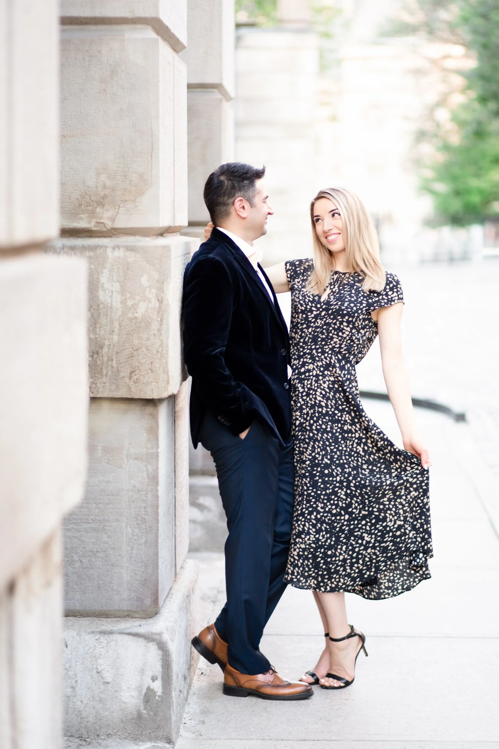 Engagement portrait along limestone columns at Osgoode Hall in downtown Toronto