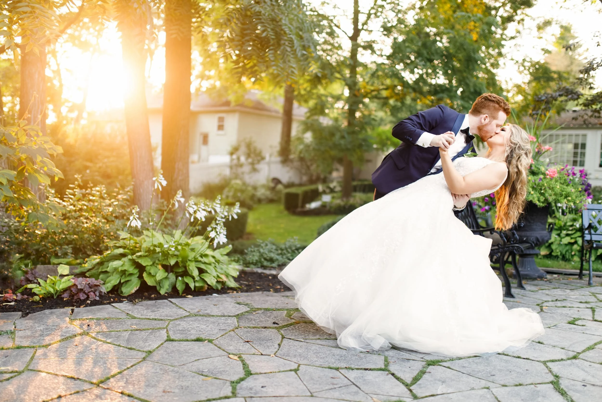 Playful golden hour wedding portrait of bride and groom dipping