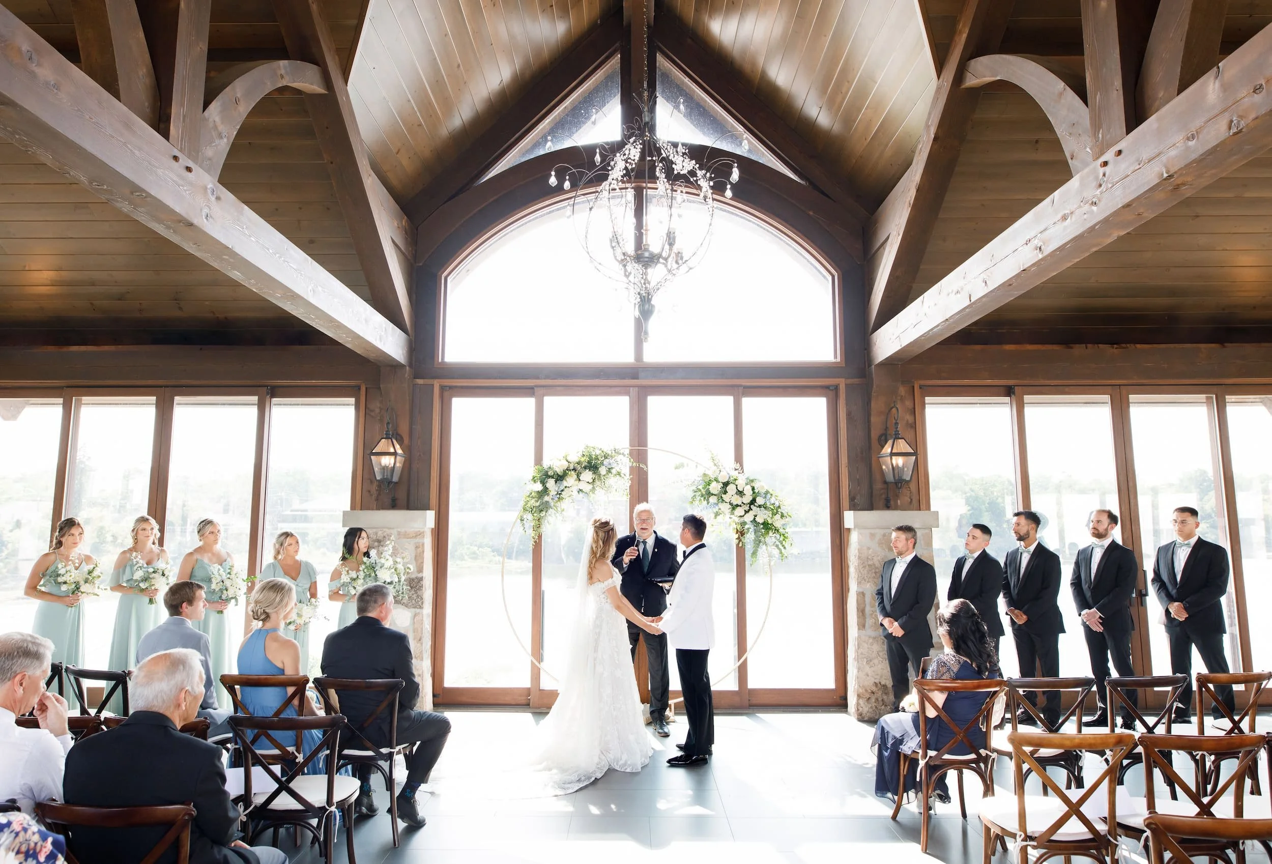 Indoor wedding ceremony beneath exposed timber beams at Cambridge Mill in Cambridge, Ontario