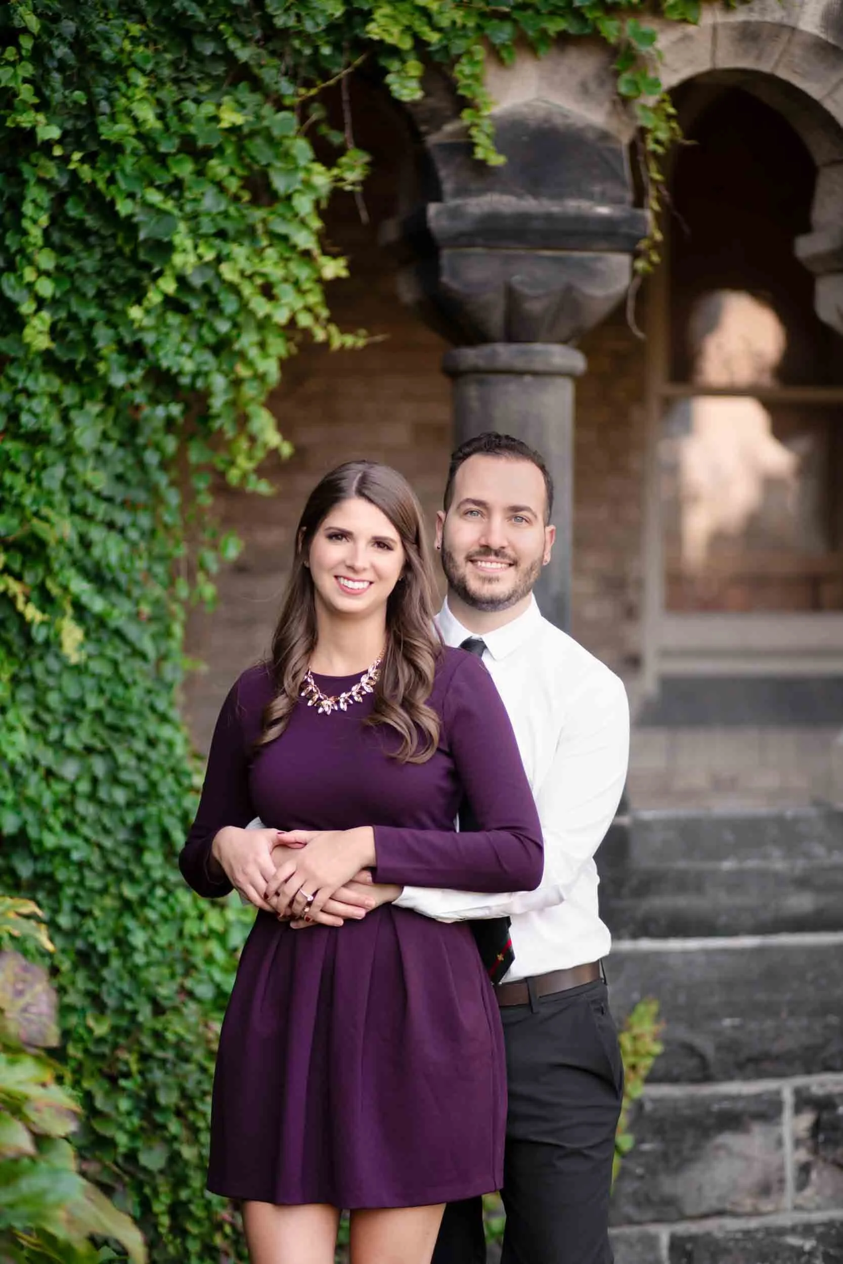 Couple portrait framed by ivy-covered entrance at Knox College, University of Toronto in Toronto, Ontario
