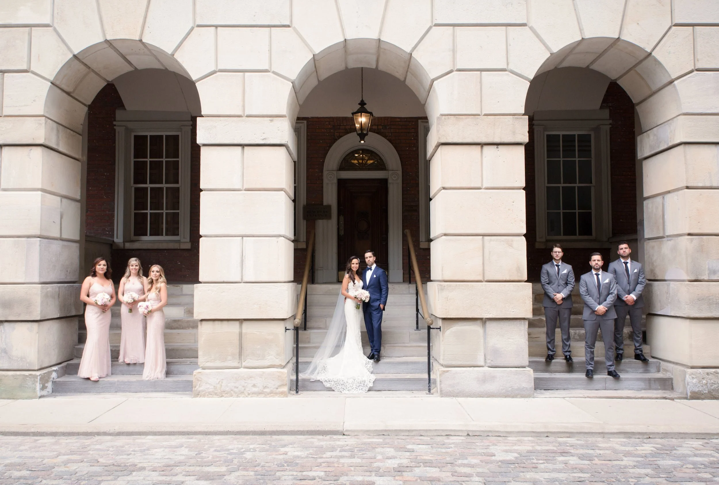 Wedding ceremony entrance framed by stone archways at Osgoode Hall