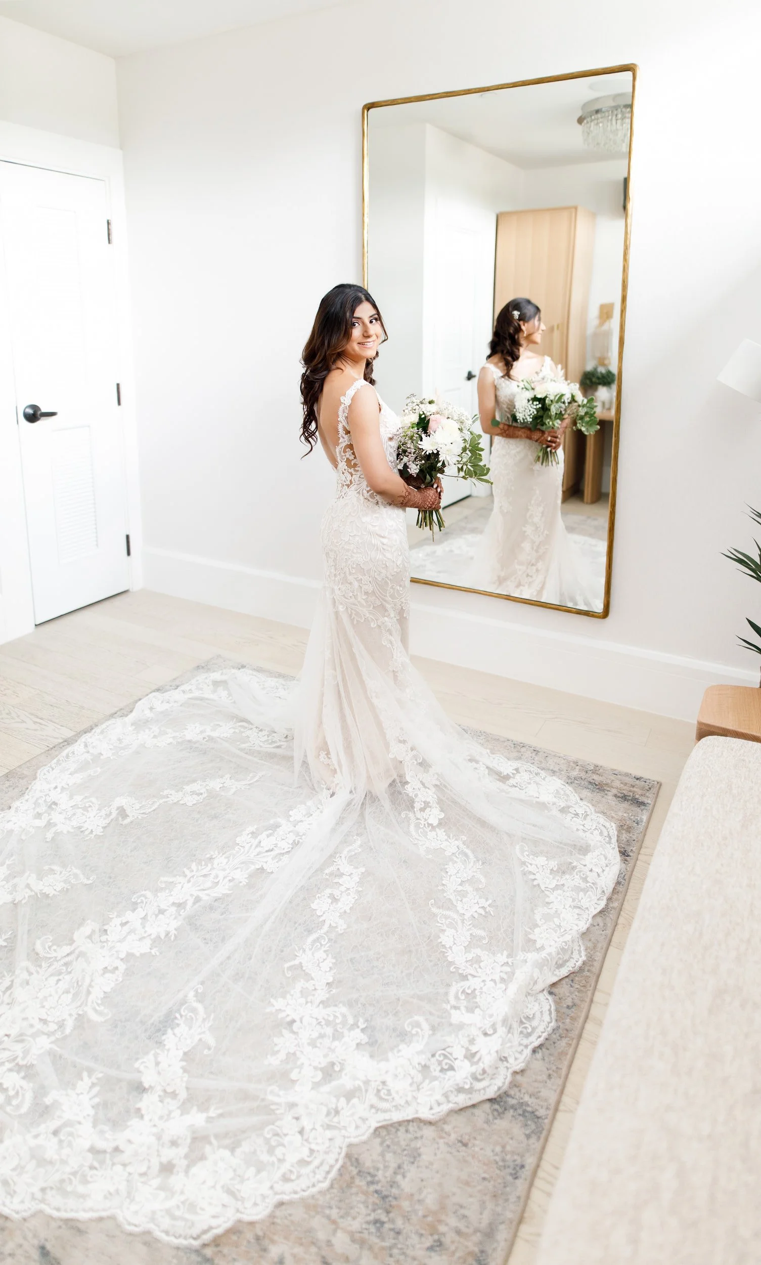 Bride in lace gown reflected in mirror in Bridal suite before Whistle Bear Golf Club wedding in Cambridge, Ontario