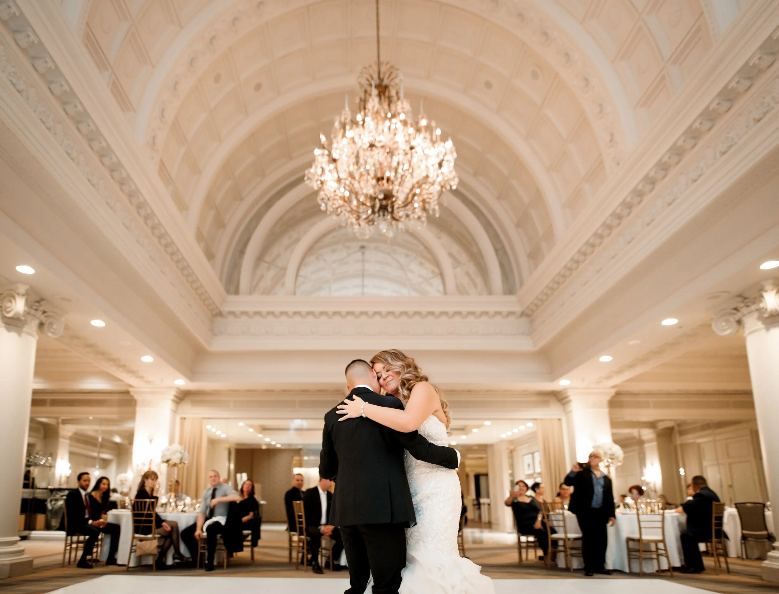 First dance beneath chandeliers in the Vanity Fair Ballroom at Omni King Edward Hotel