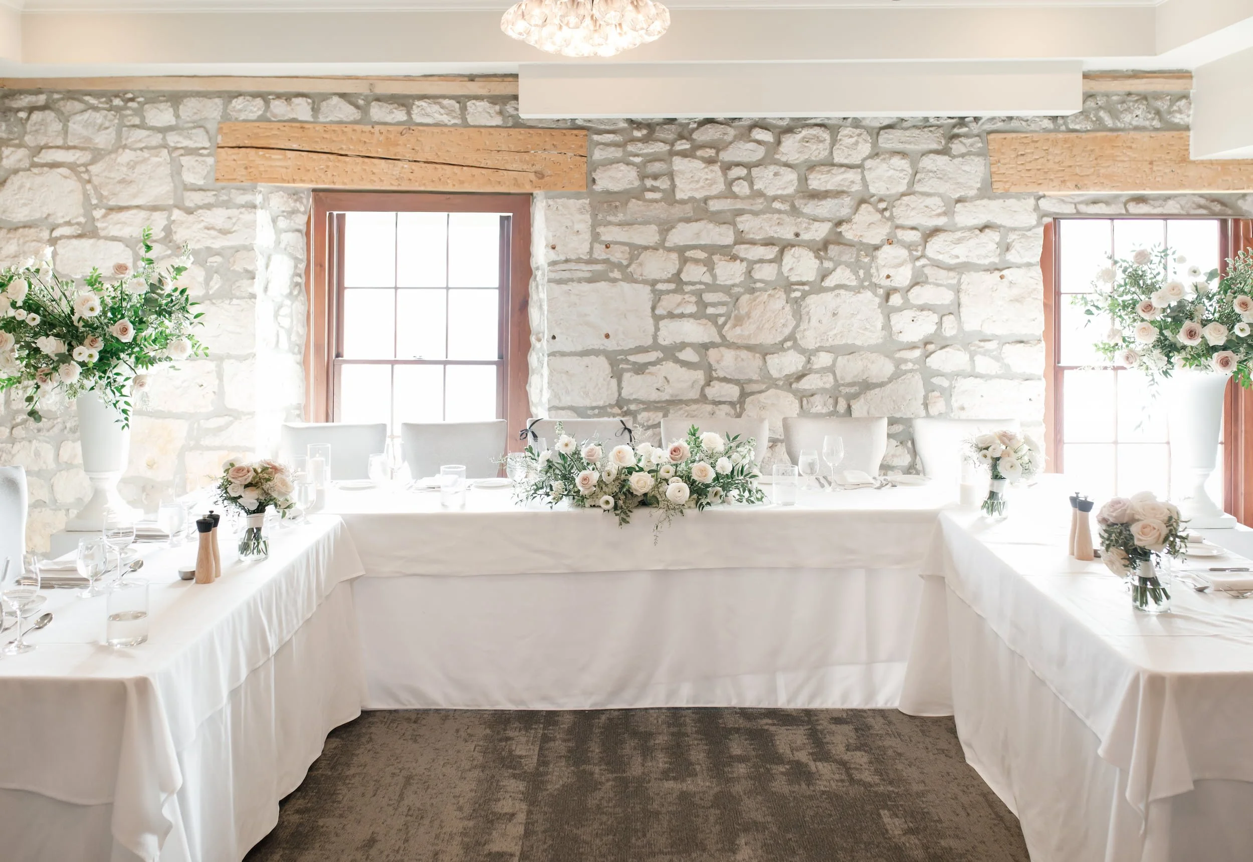 Reception head table against limestone wall at Cambridge Mill in Cambridge, Ontario