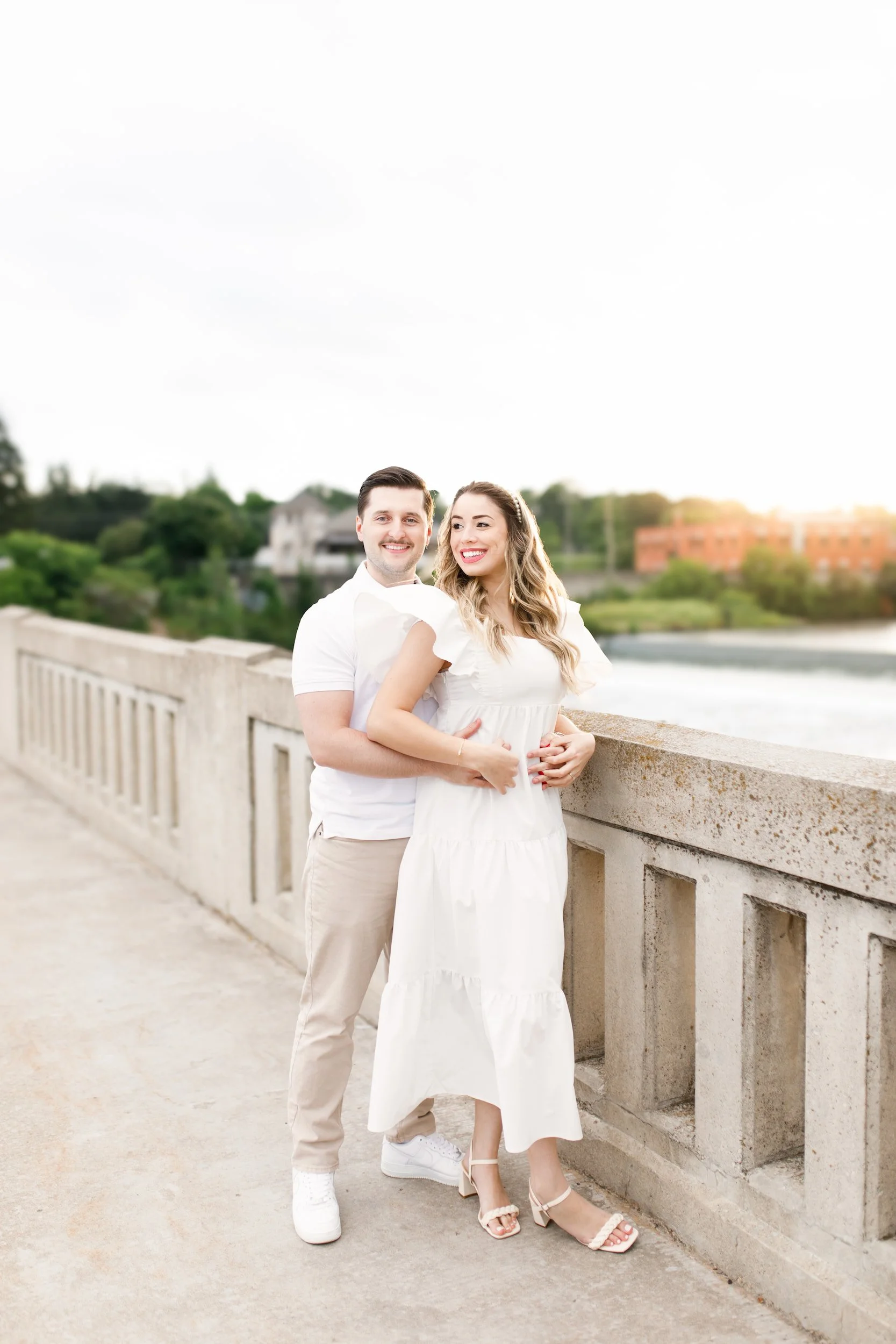 Engagement portrait along Mill Race Park river railing in Cambridge, Ontario