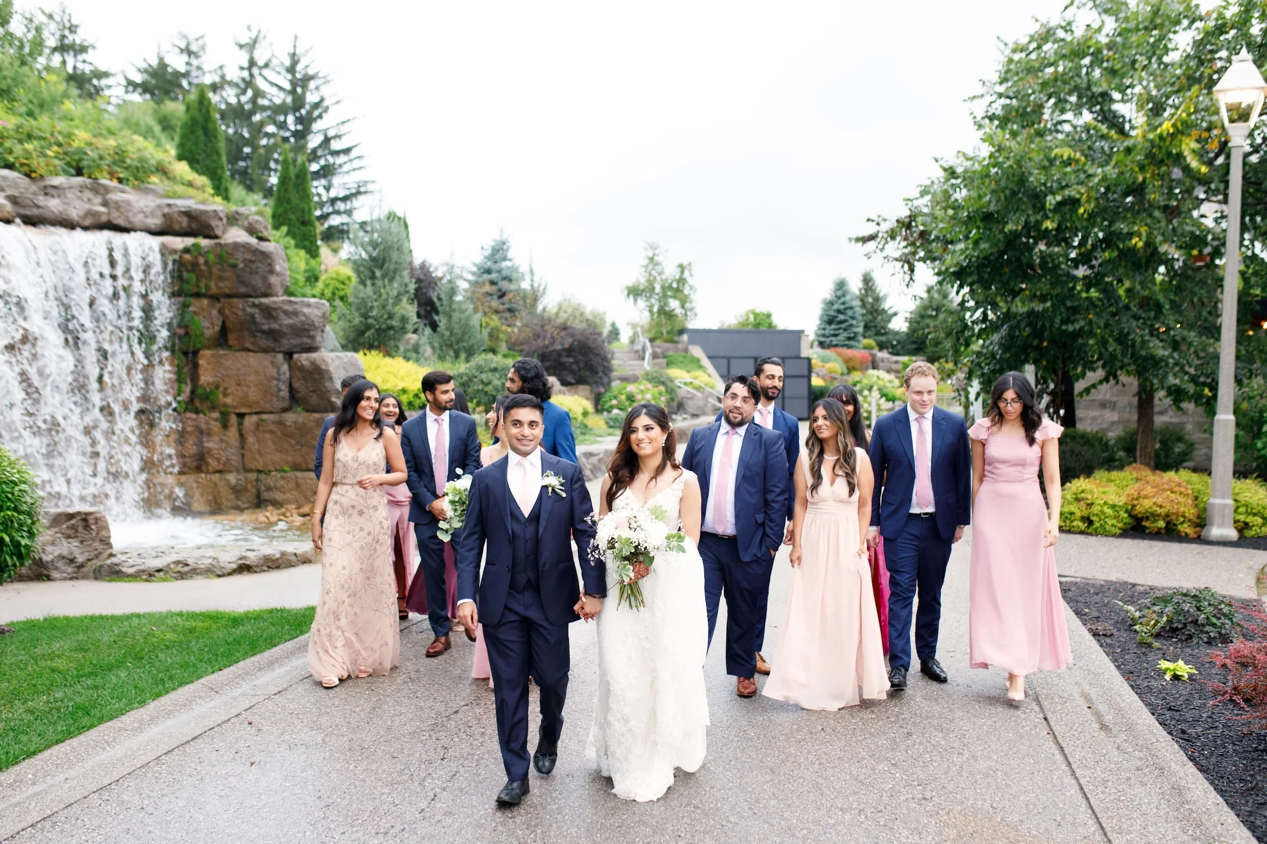 Wedding party walking along stone pathway at Whistle Bear Golf Club in Cambridge, Ontario