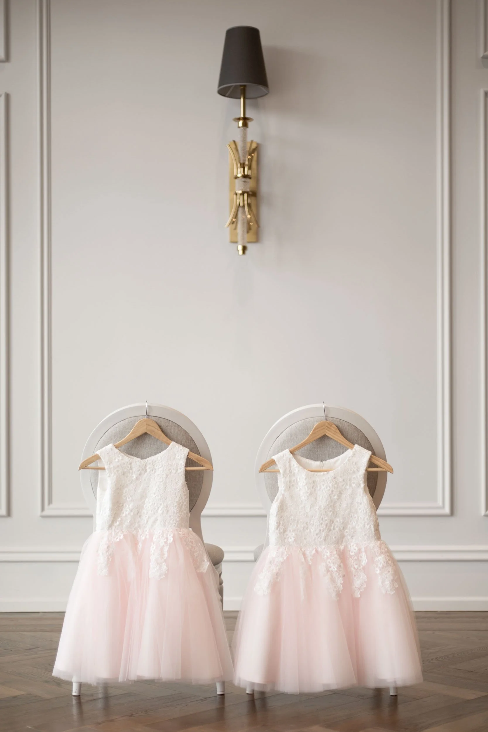 Flower girl dresses hanging in the Arlington Estate bridal suite chairs in Vaughan