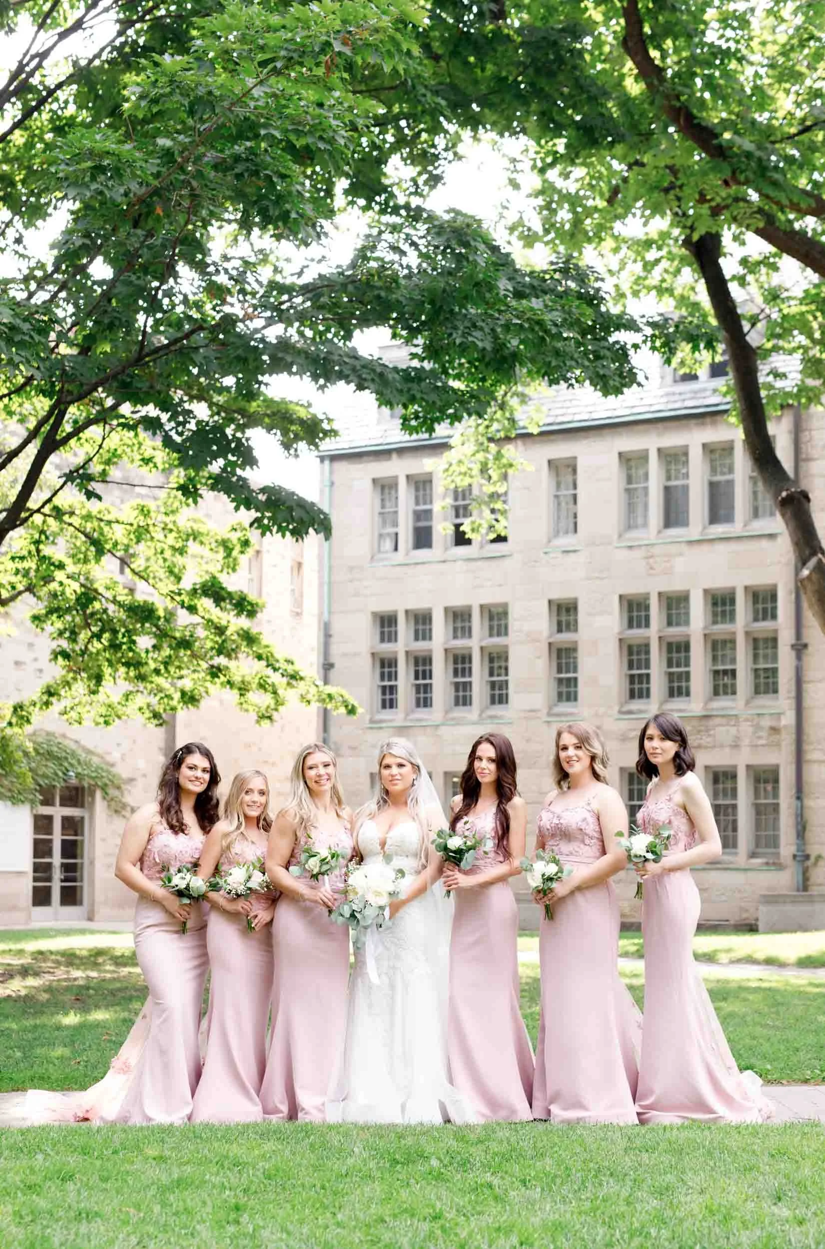 Bride and bridesmaids in blush dresses at St. Michael’s College, University of Toronto in Toronto, Ontario