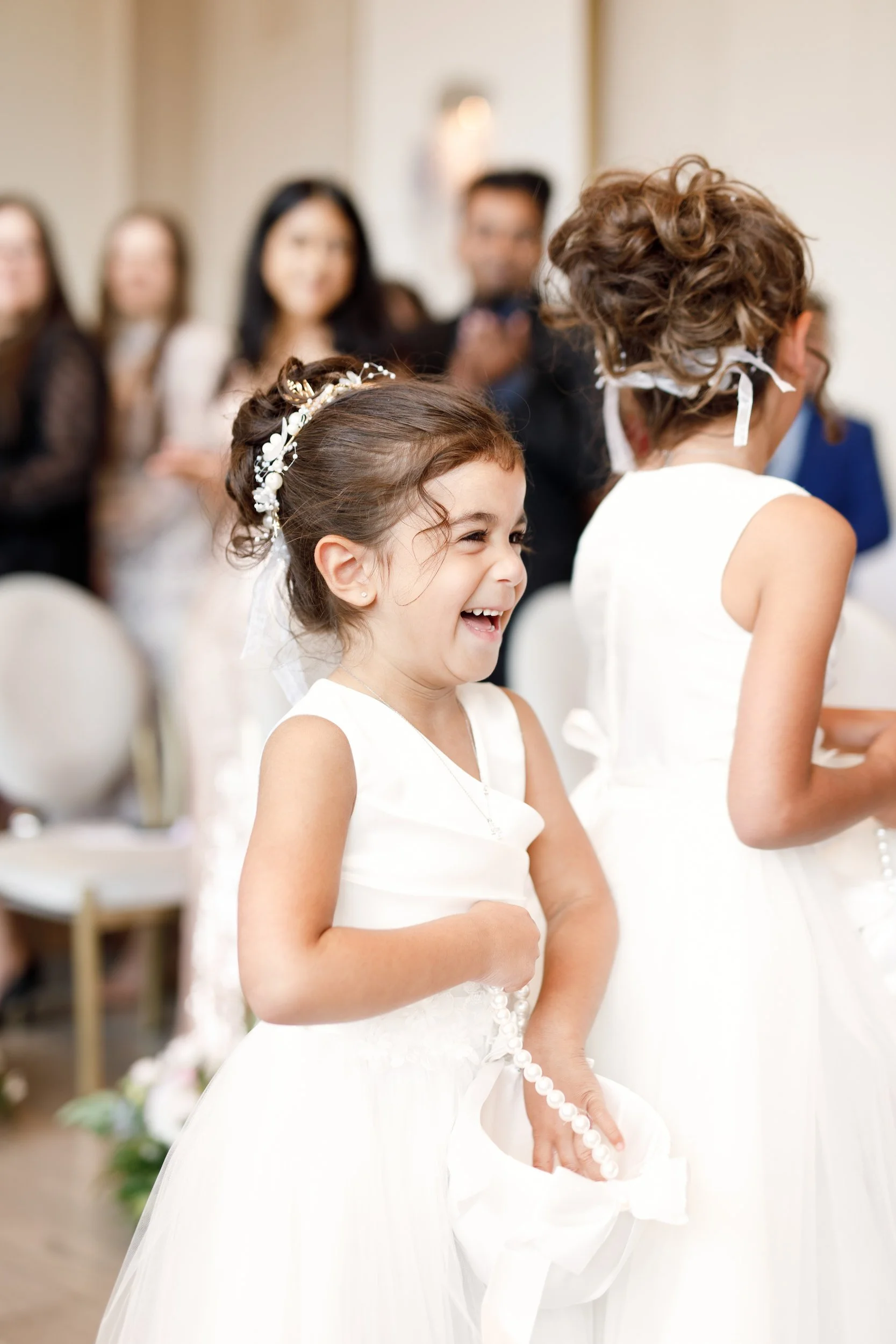 Flower girl laughing during wedding ceremony at The Pearle Hotel in Burlington