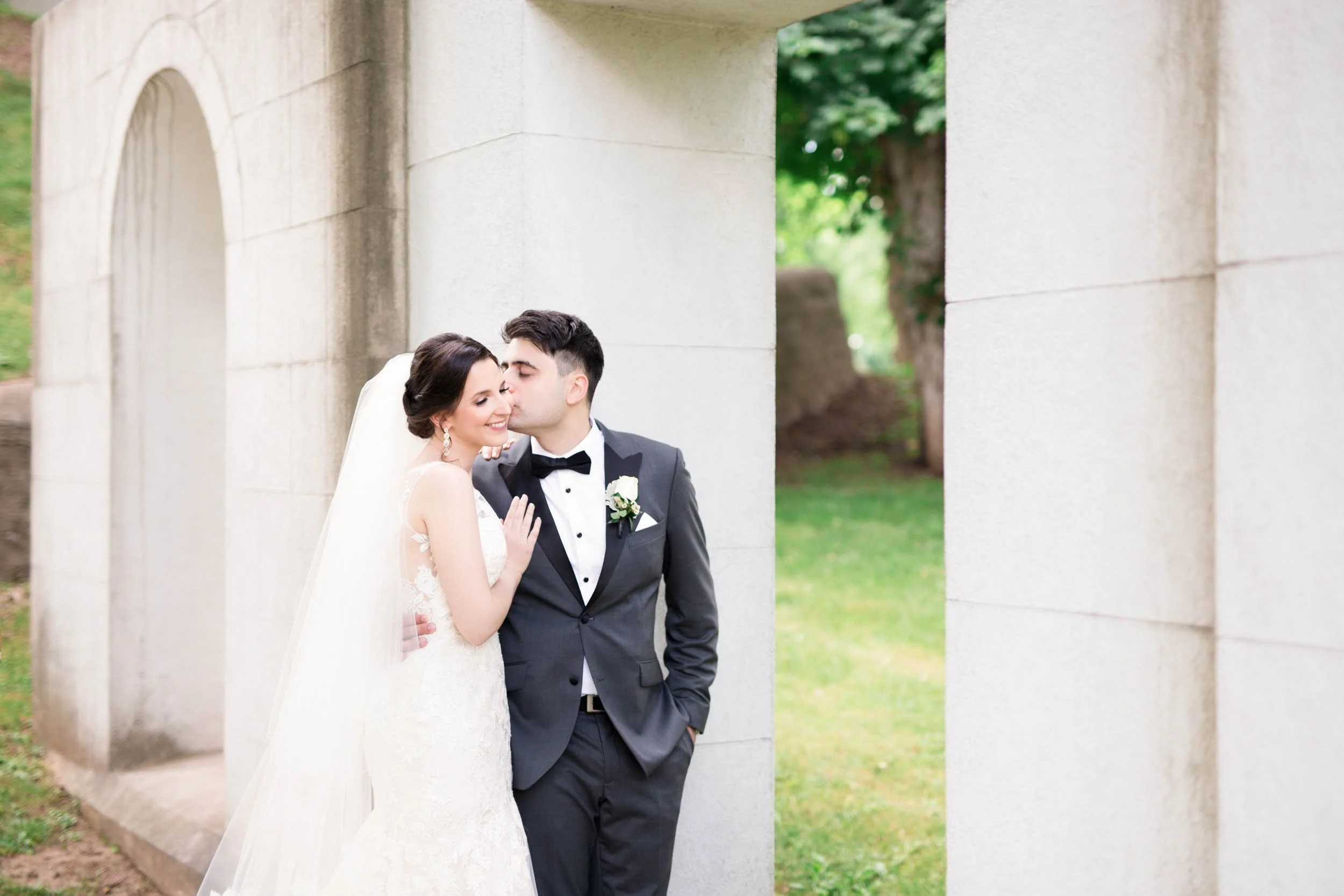 Bride and groom portrait under stone arch at Dundurn Castle