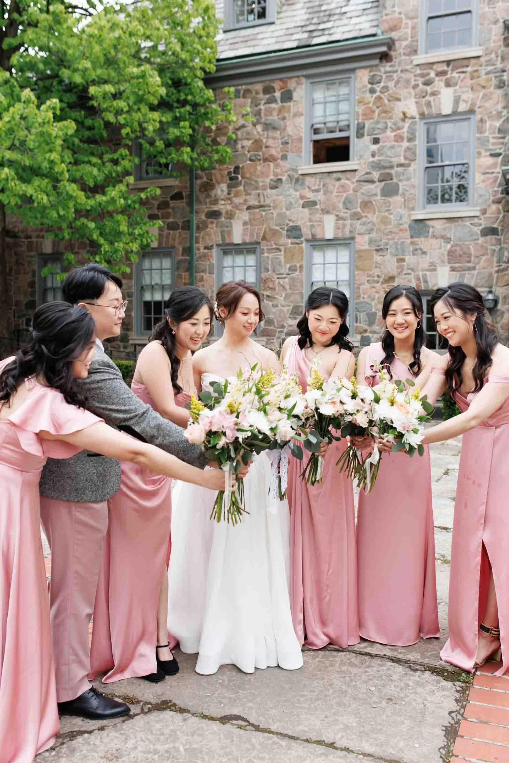 Bridesmaids with bouquets in Graydon Hall Manor courtyard