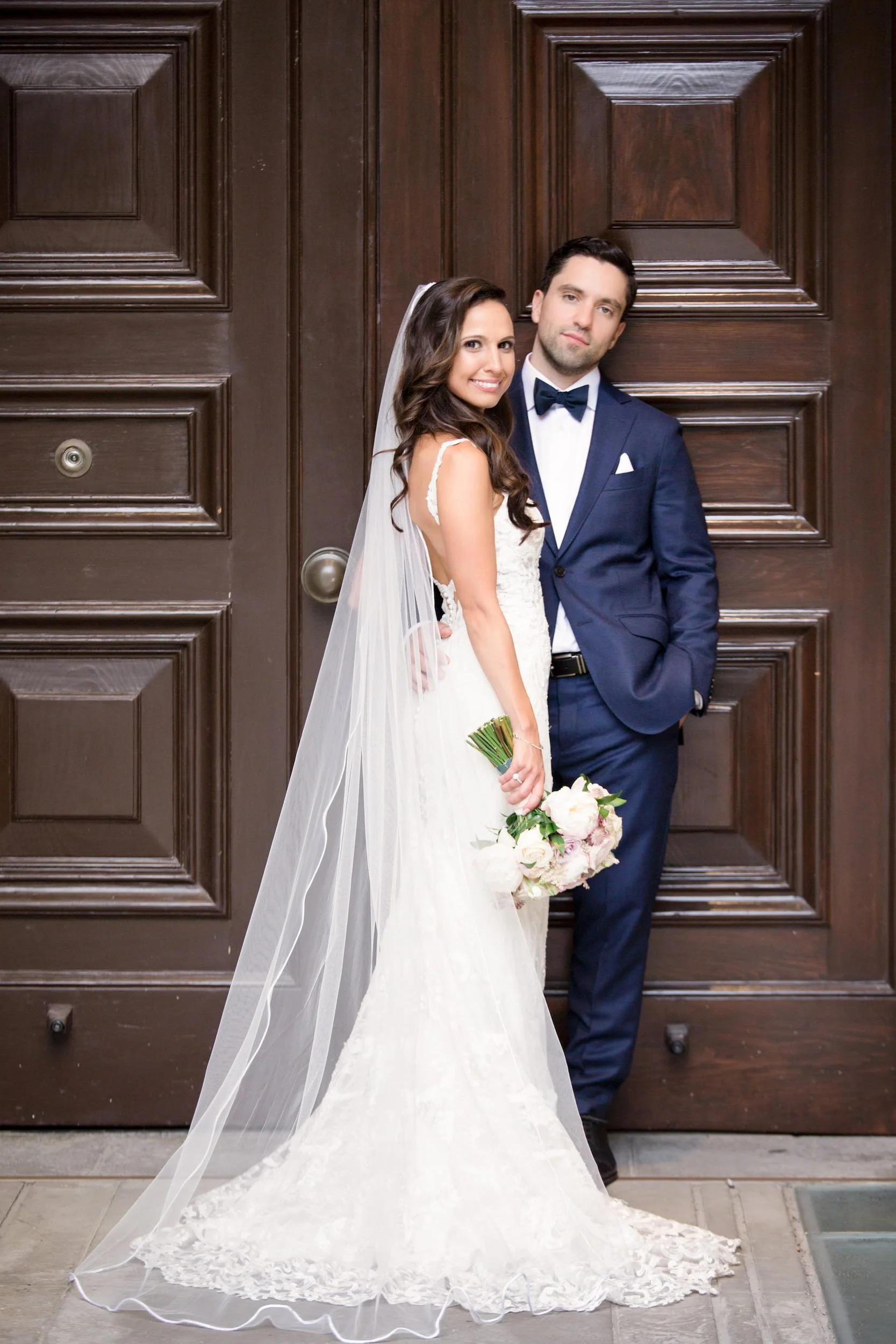 Bride and groom portrait at historic wooden doors of Osgoode Hall courthouse