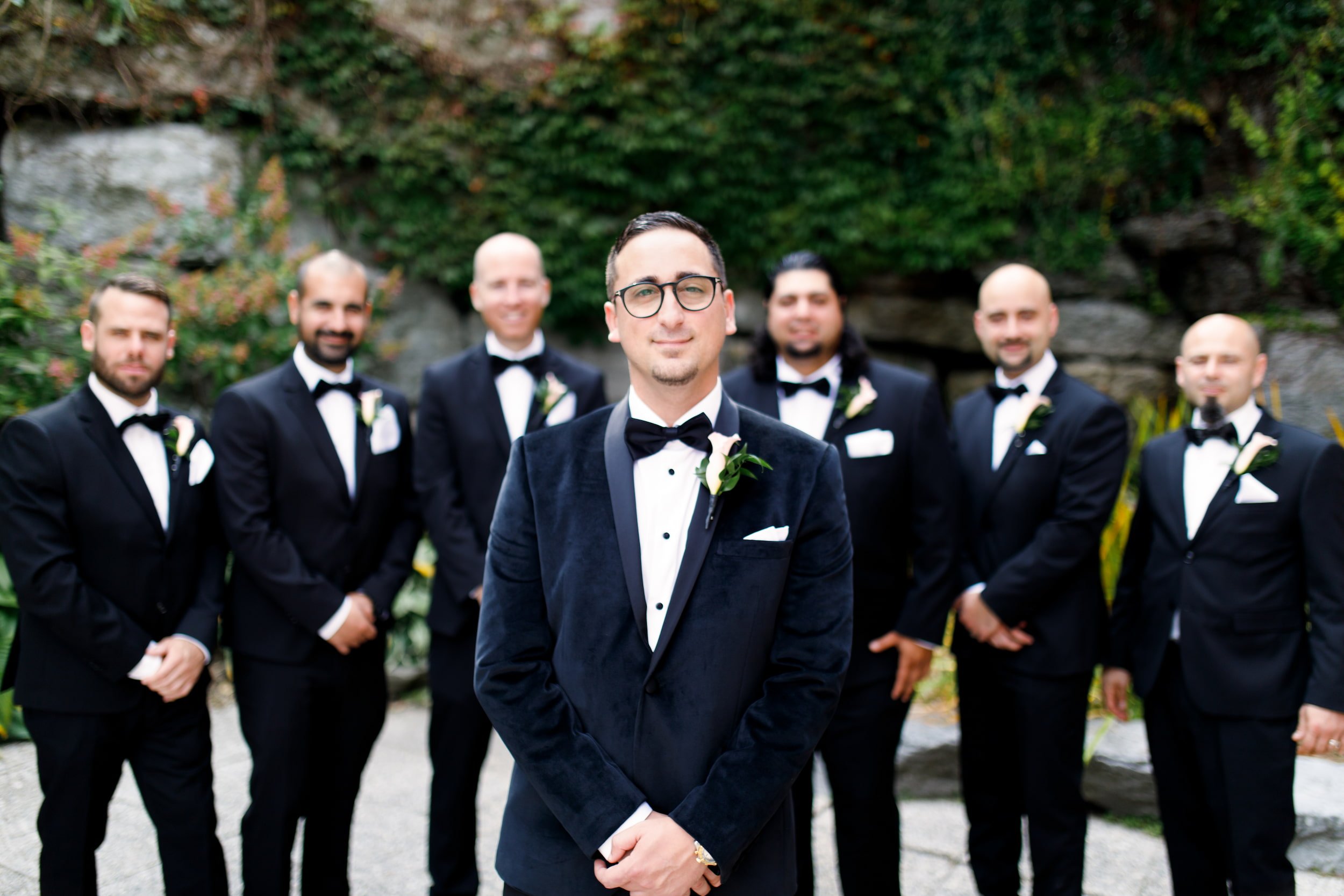 Groom and groomsmen in black tuxedos during formal portraits at The Manor Event Venue wedding in King, Ontario