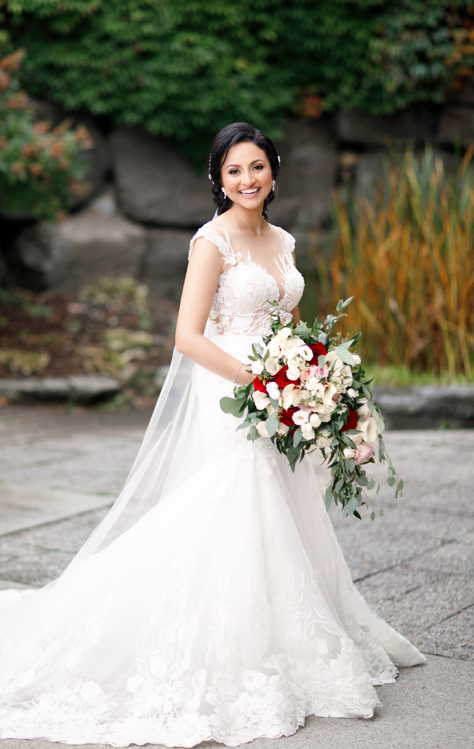 Bridal portrait with flowing veil and vibrant bouquet at The Manor Event Venue in King, Ontario