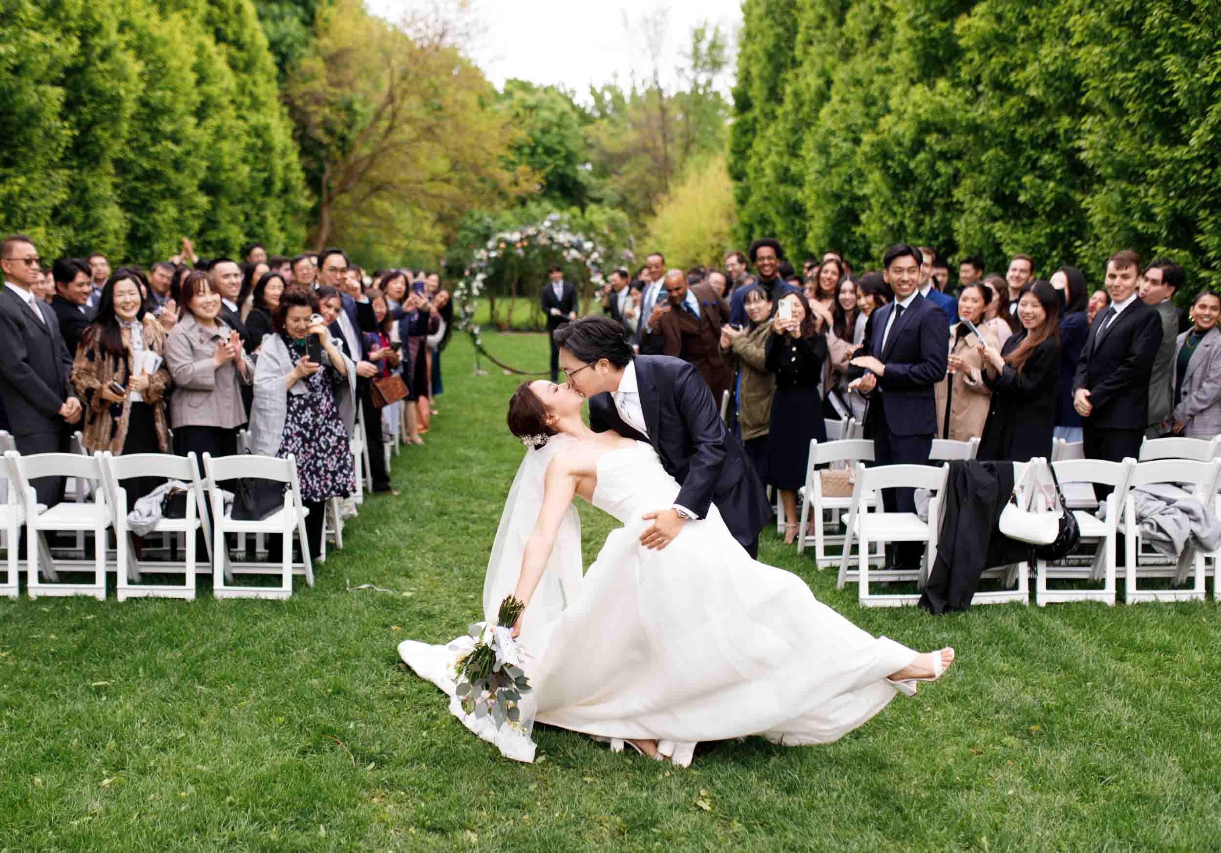 Bride and groom dip kiss during ceremony recessional at Graydon Hall Manor