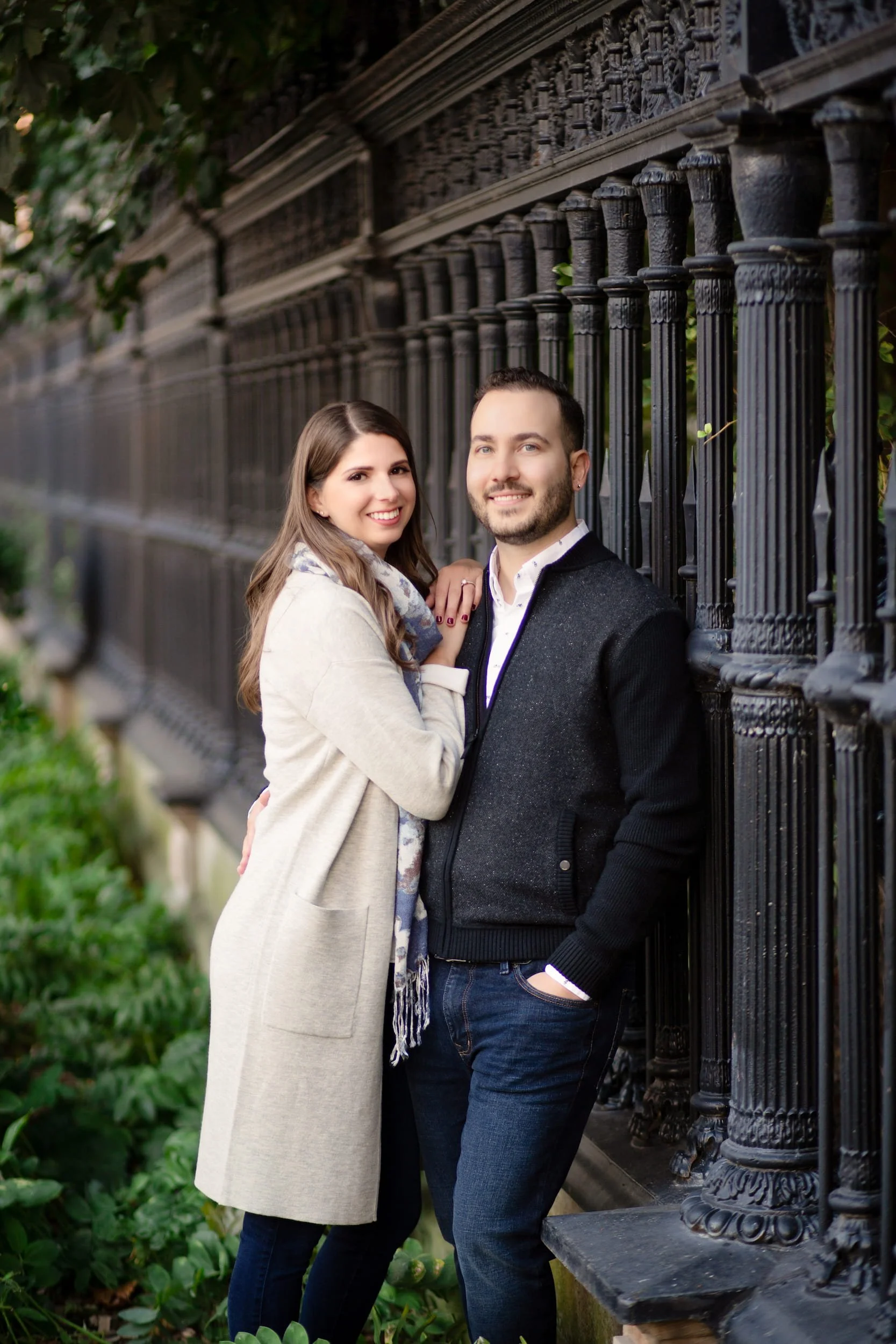 Engagement portrait along historic wrought iron gates at Osgoode Hall in Toronto