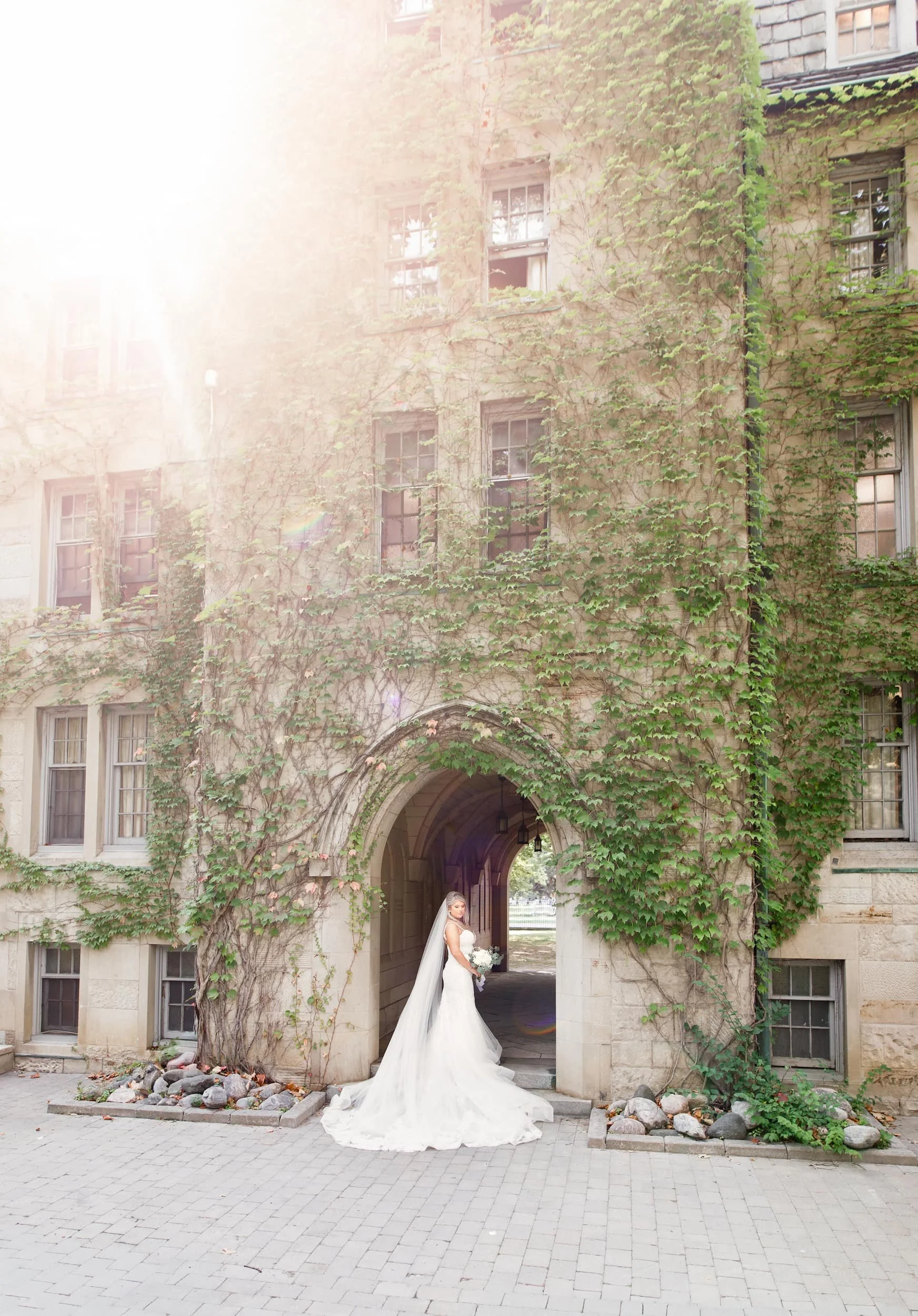 Bride beneath vine-covered Gothic archway at St. Michael’s College, University of Toronto in Toronto, Ontario
