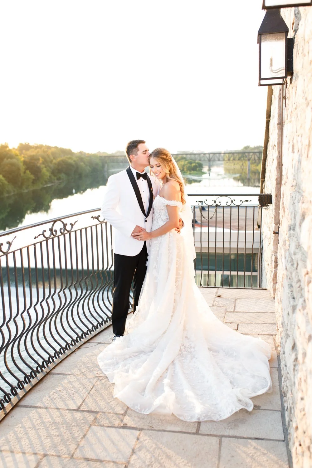 Full-length bride and groom portrait on the terrace at Cambridge Mill during sunset in Cambridge, Ontario