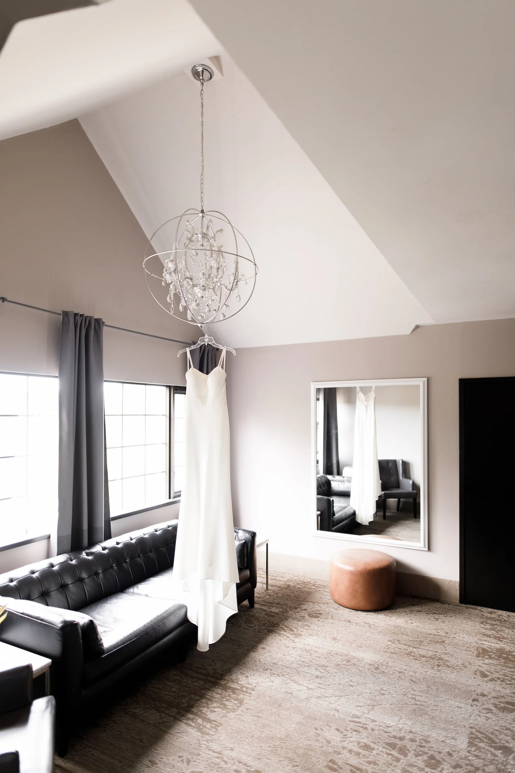 Bridal gown hanging in modern suite with chandelier at The Manor Event Venue in King, Ontario