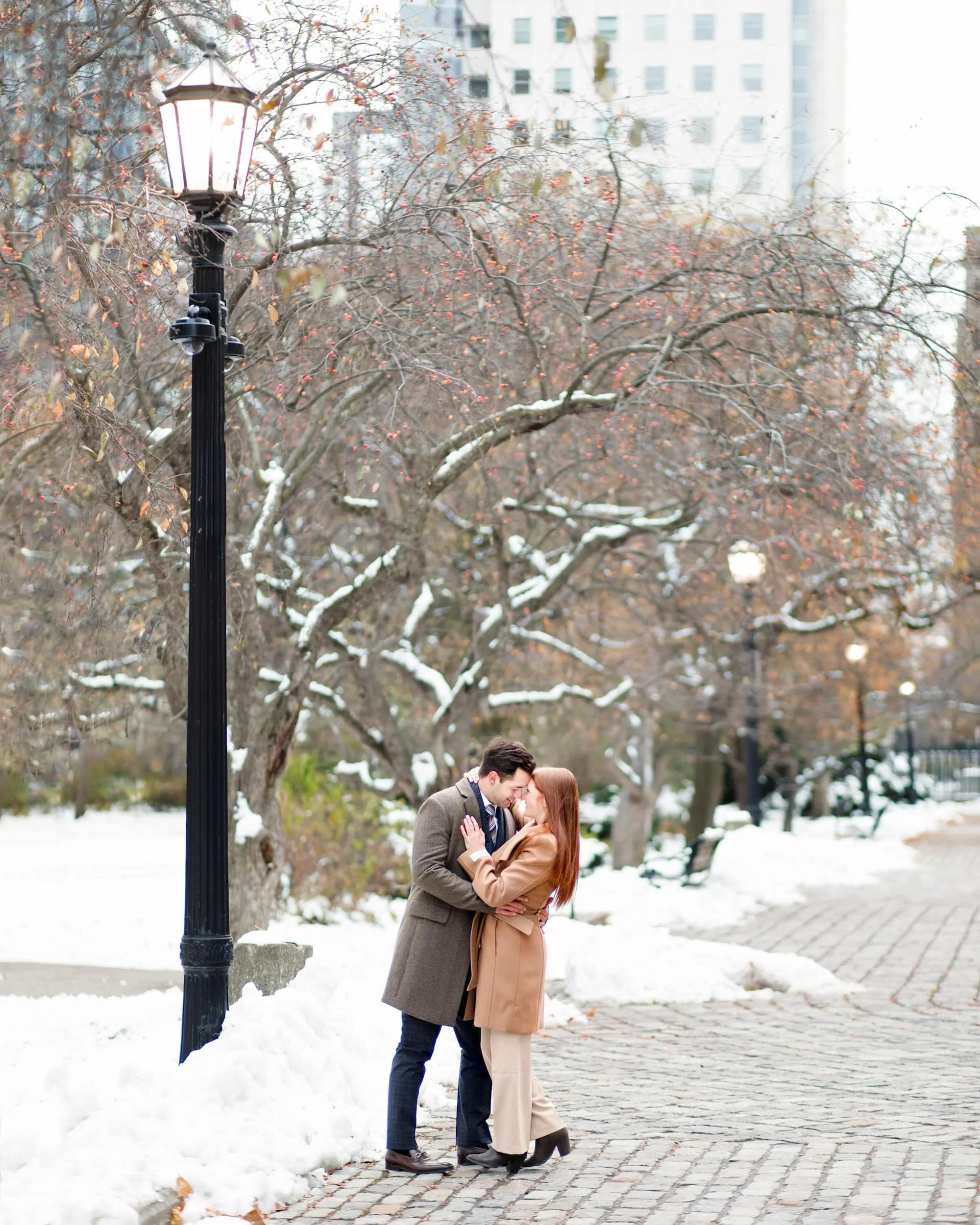 Romantic winter engagement session under lamppost at Osgoode Hall courtyard