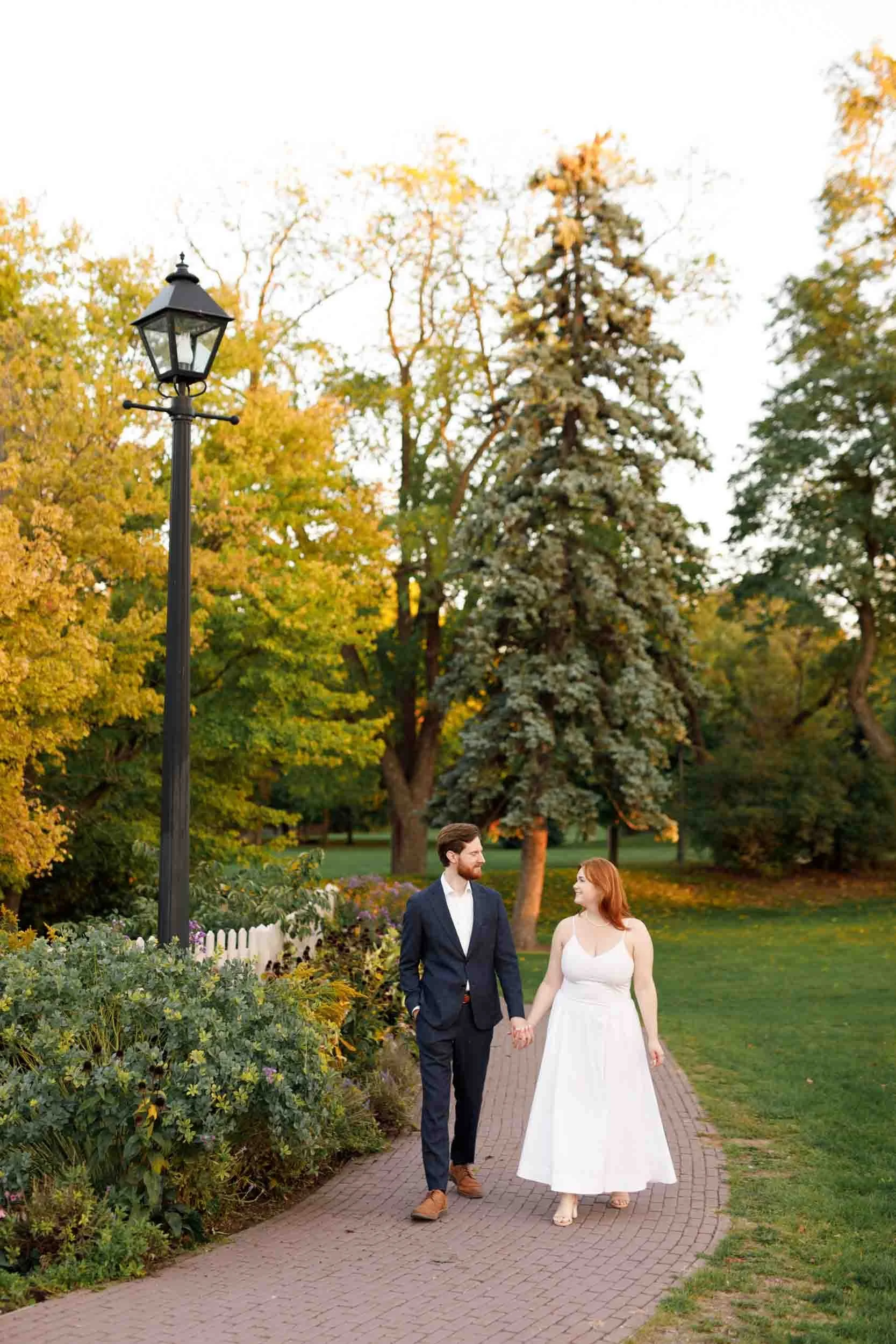 Bride and groom walking through Dundurn Castle gardens in autumn