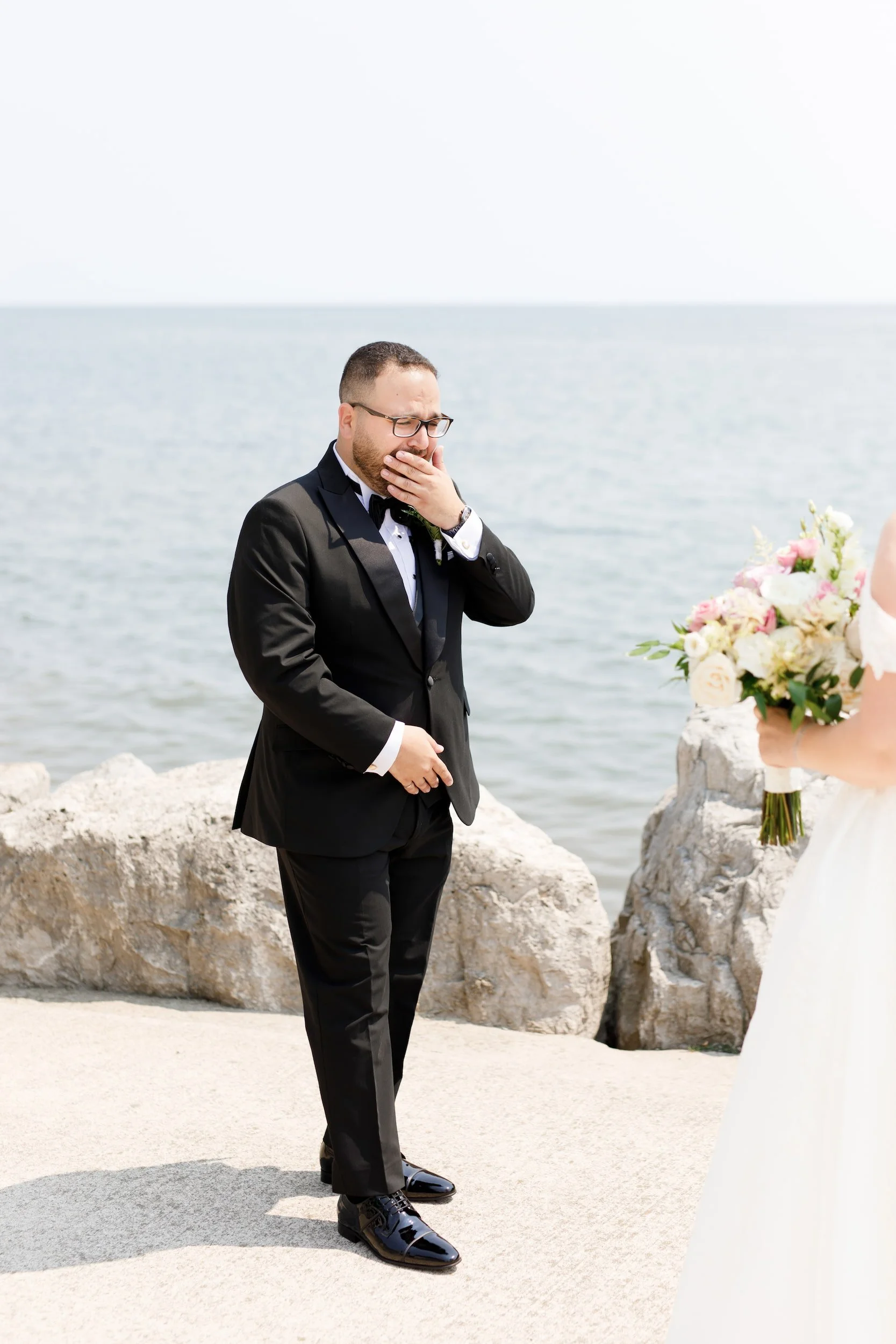 Groom emotional first look reaction on Burlington waterfront near The Pearle Hotel