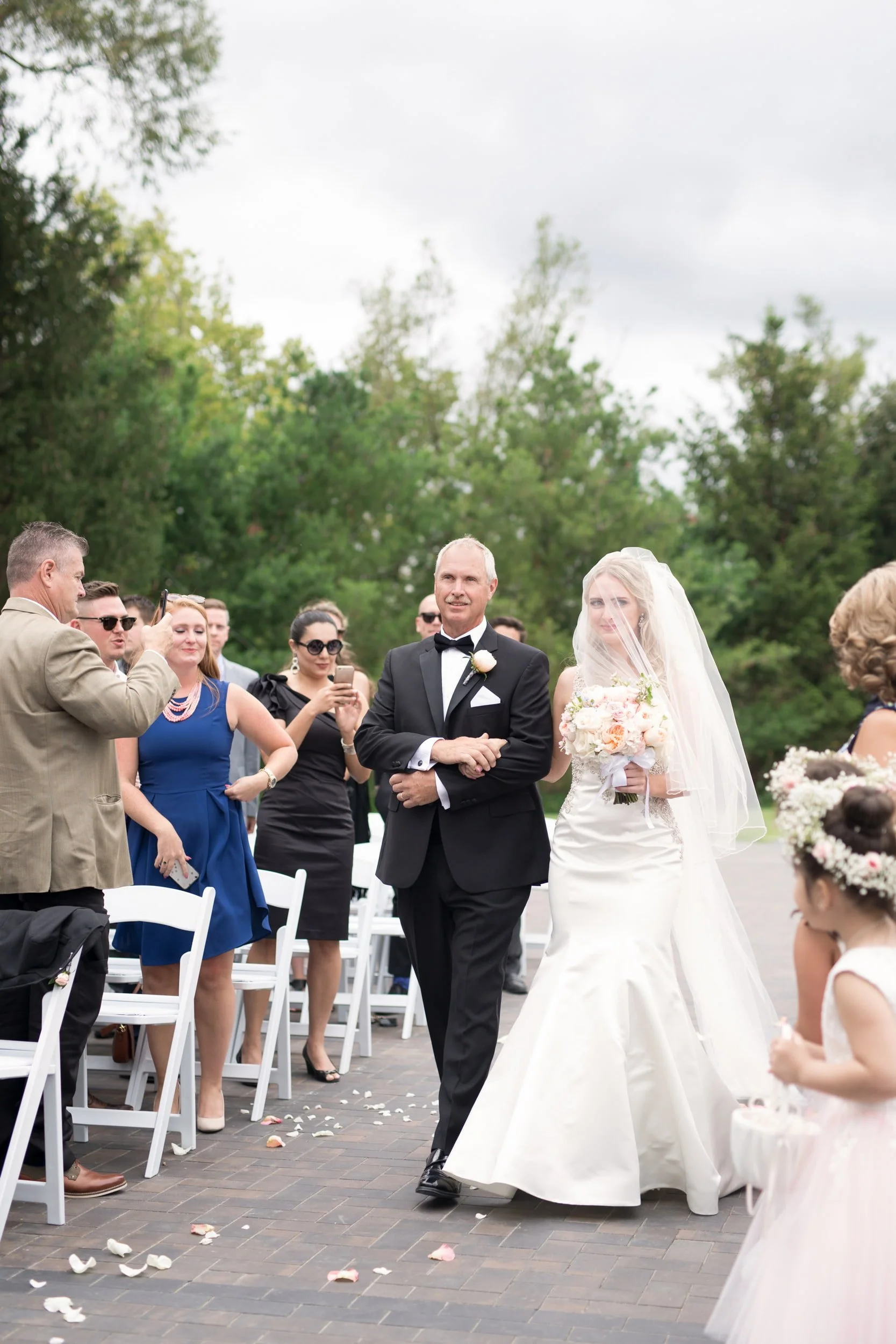 Bride walking down the aisle with her father during an outdoor Arlington Estate wedding ceremony in Vaughan