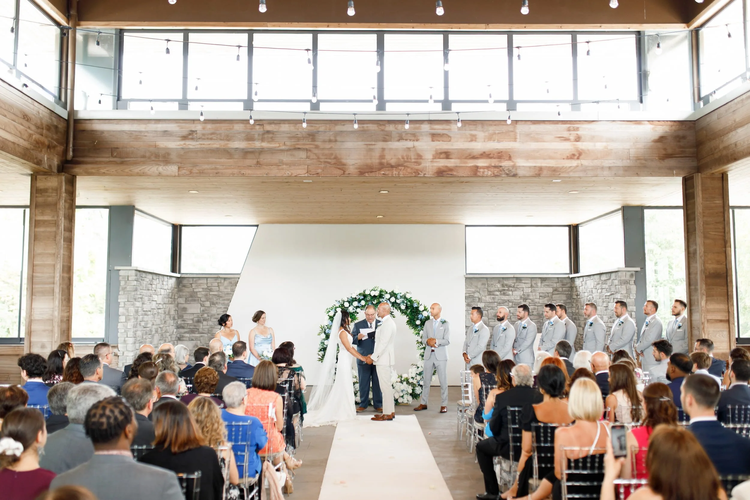 Indoor wedding ceremony with floral arch at Guild Inn Estate