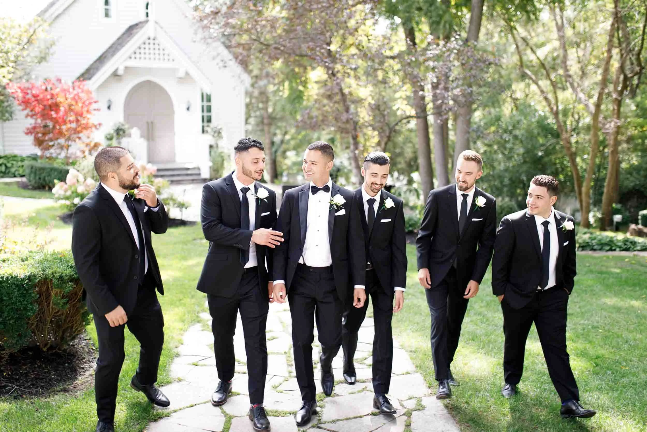Groomsmen walking along tree-lined path at The Doctor’s House in Kleinburg, Ontario