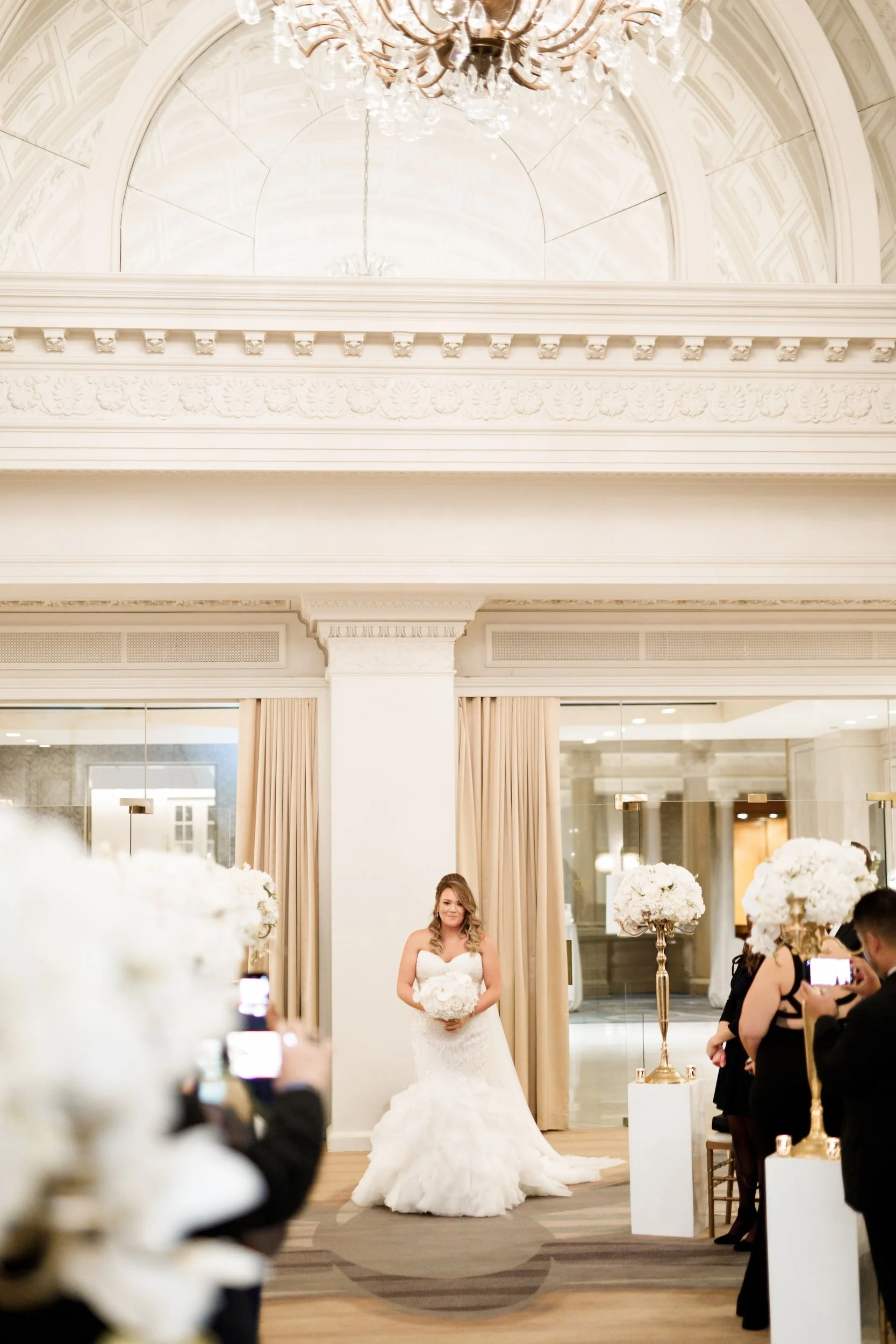Bride walking down the aisle in the Vanity Fair Ballroom Ceremony at Omni King Edward Hotel in Toronto