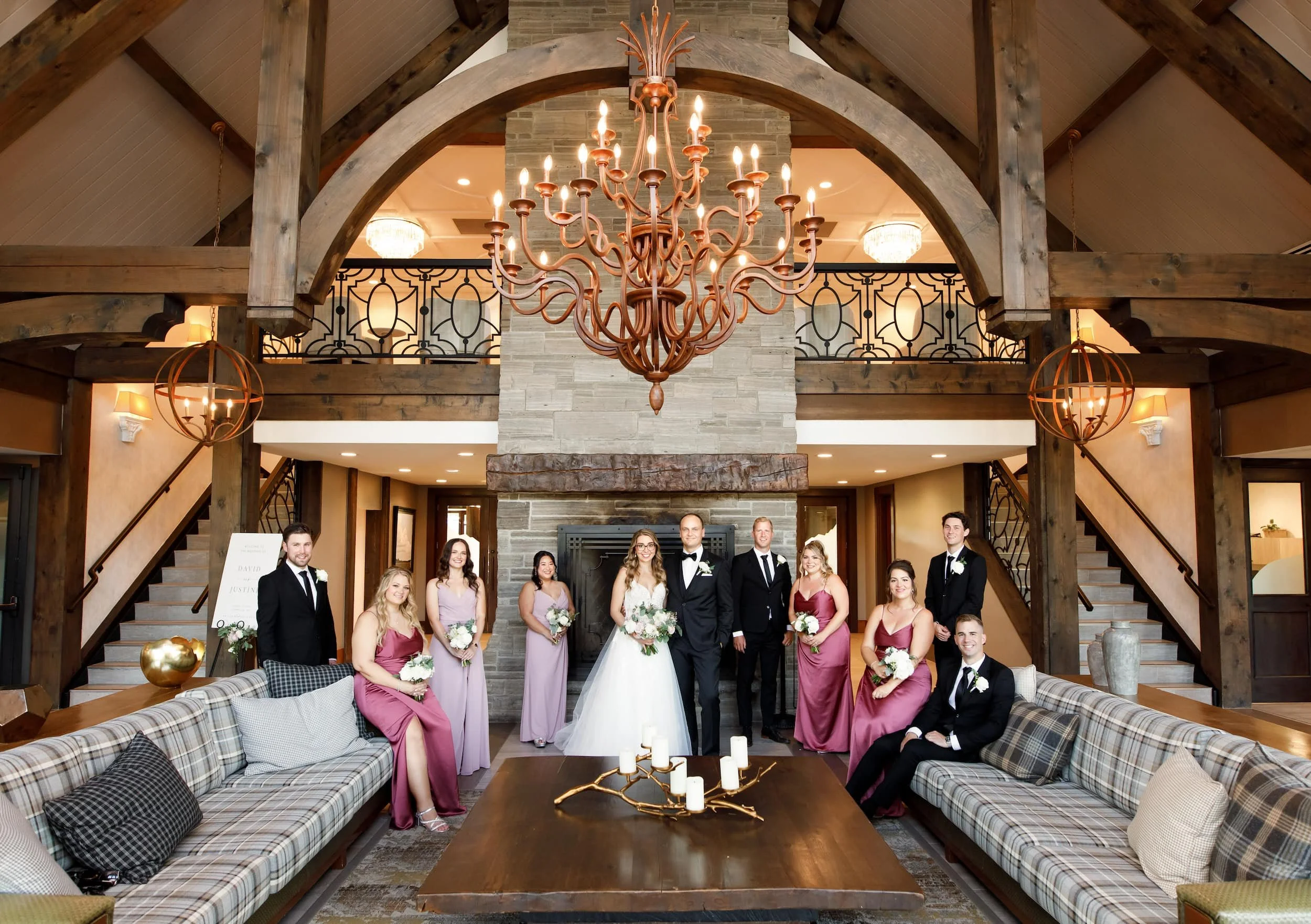 Wedding party gathered beneath chandelier in reception hall at Whistle Bear Golf Club in Cambridge, Ontario