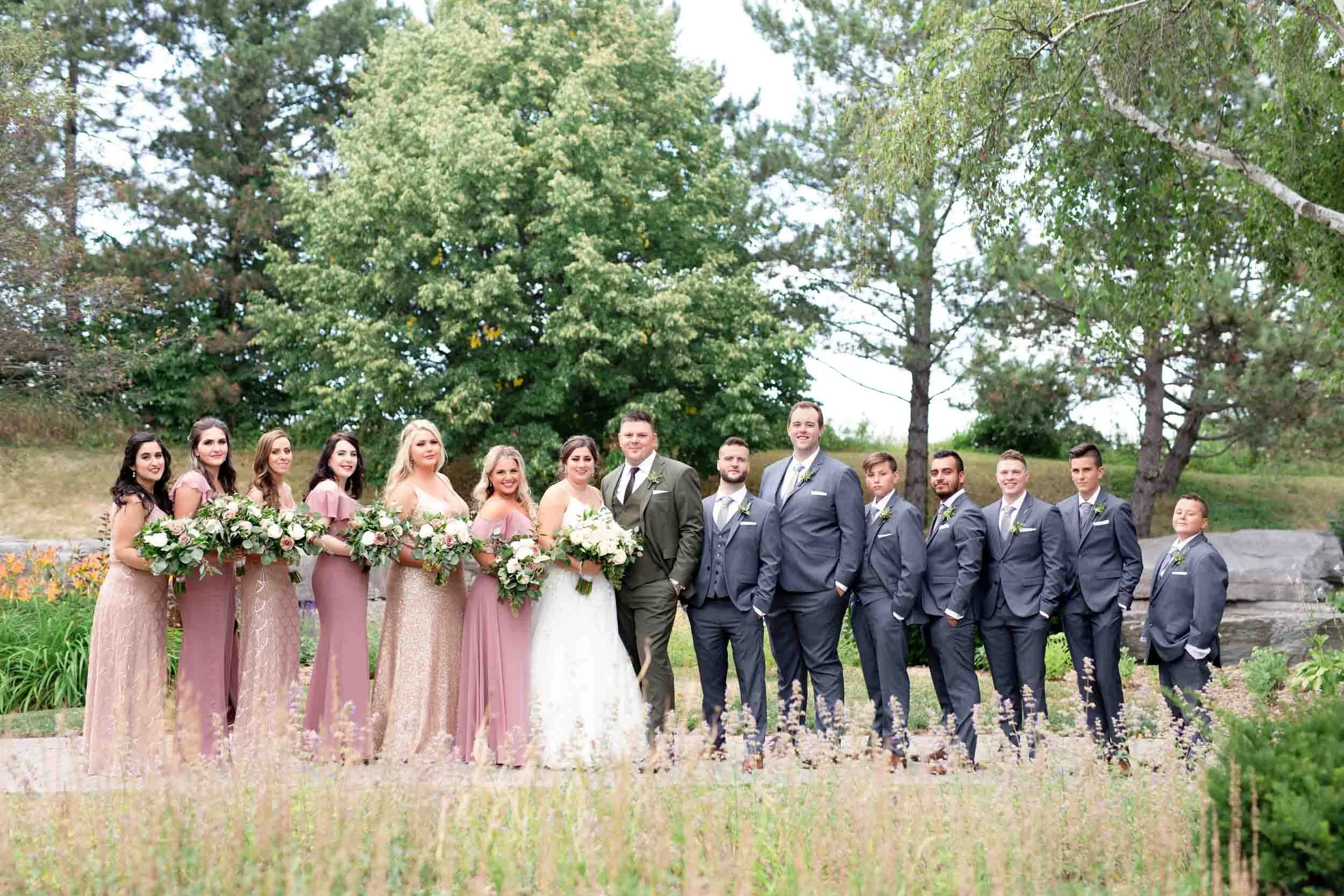 Bride and groom with wedding party in coordinated attire at The Manor Event Venue in King, Ontario
