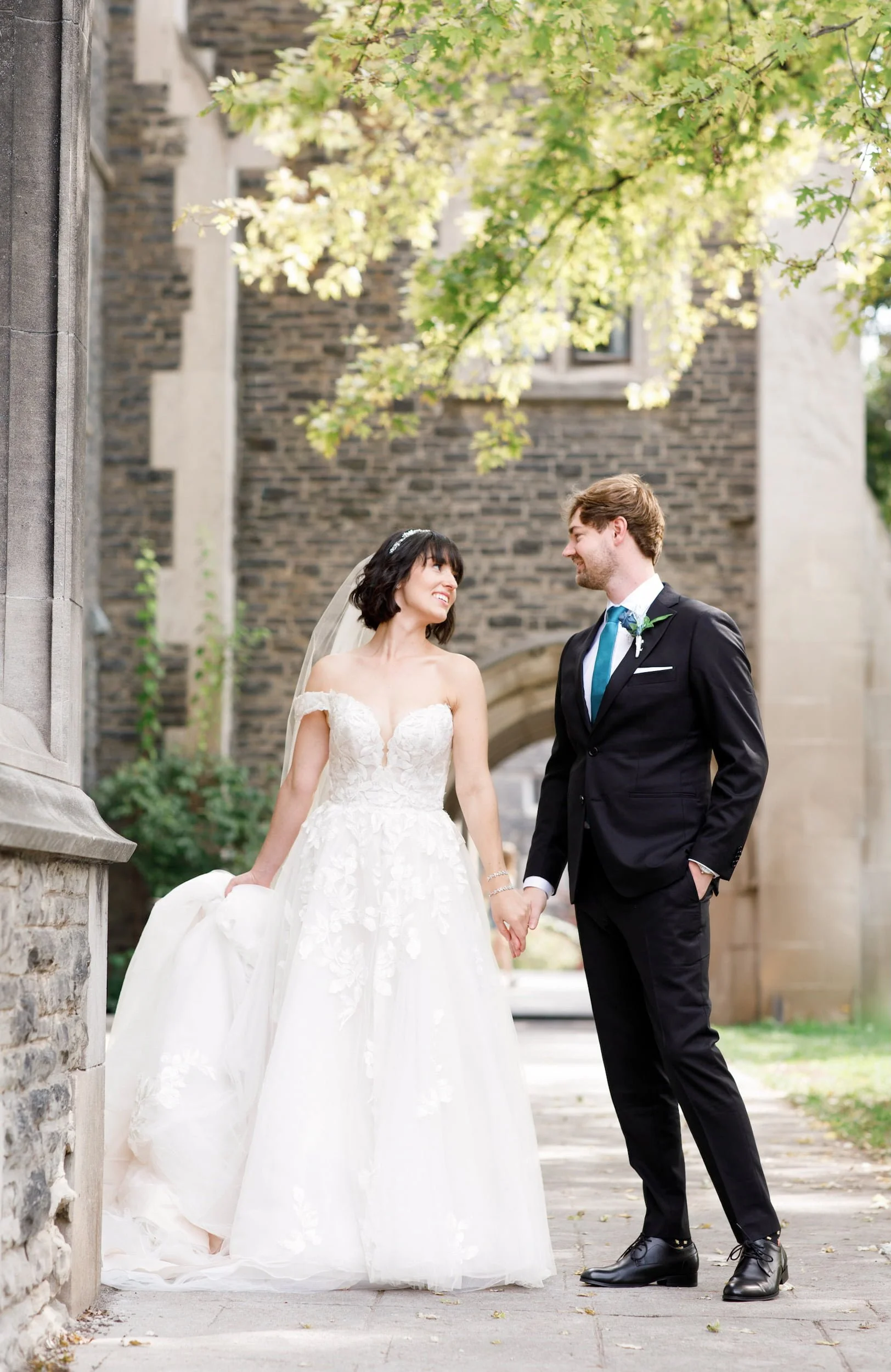 Romantic couple portrait along stone wall at Victoria College, University of Toronto in Toronto, Ontario