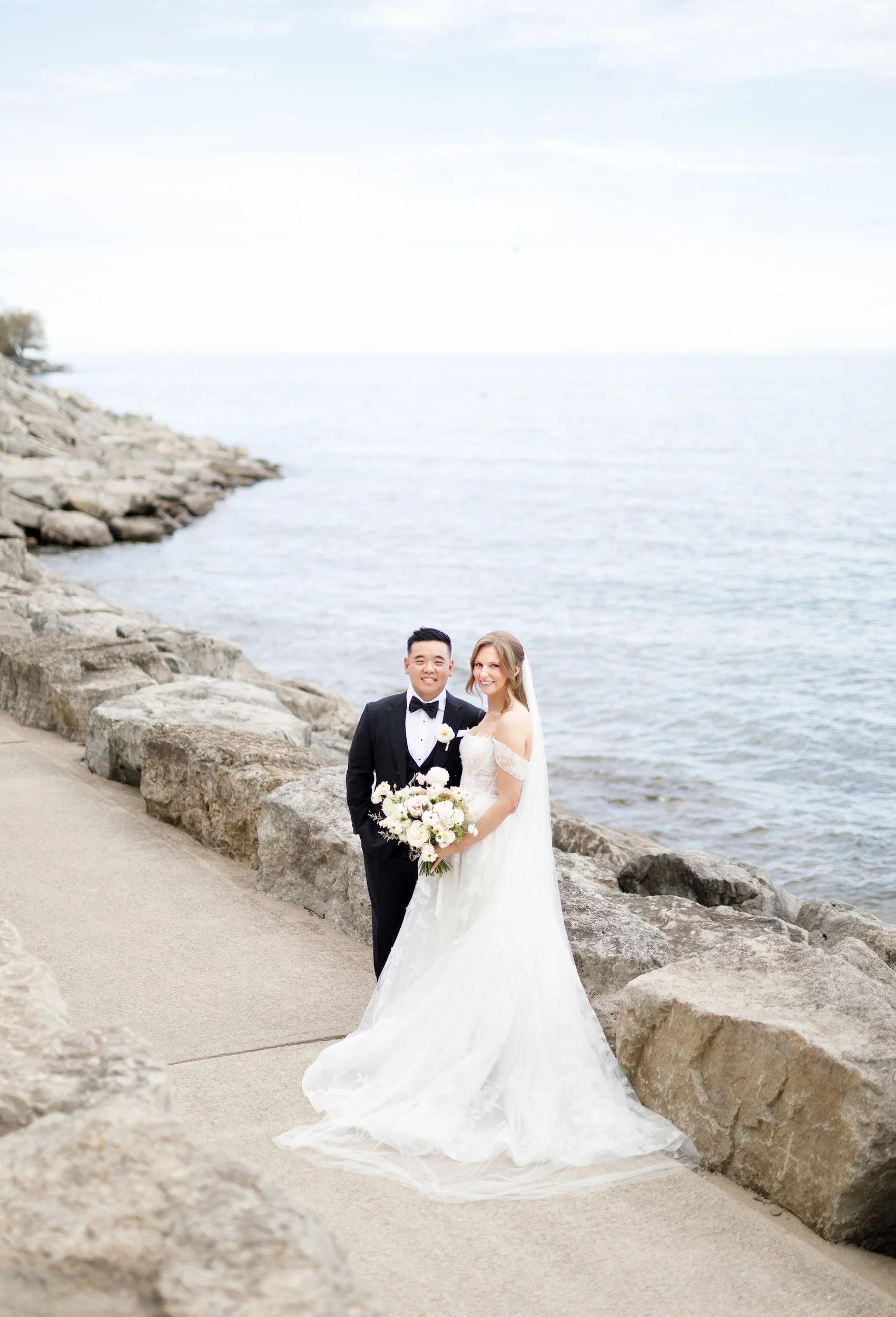 Bride and groom portrait along Lake Ontario shoreline near The Pearle Hotel in Burlington