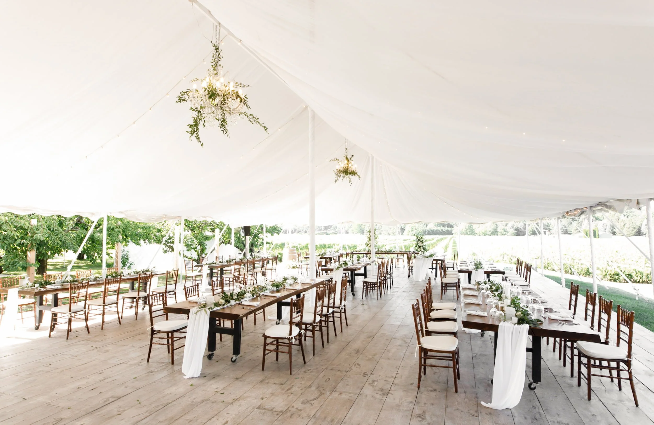 Elegant tent reception with wooden harvest tables at Gracewood Estate