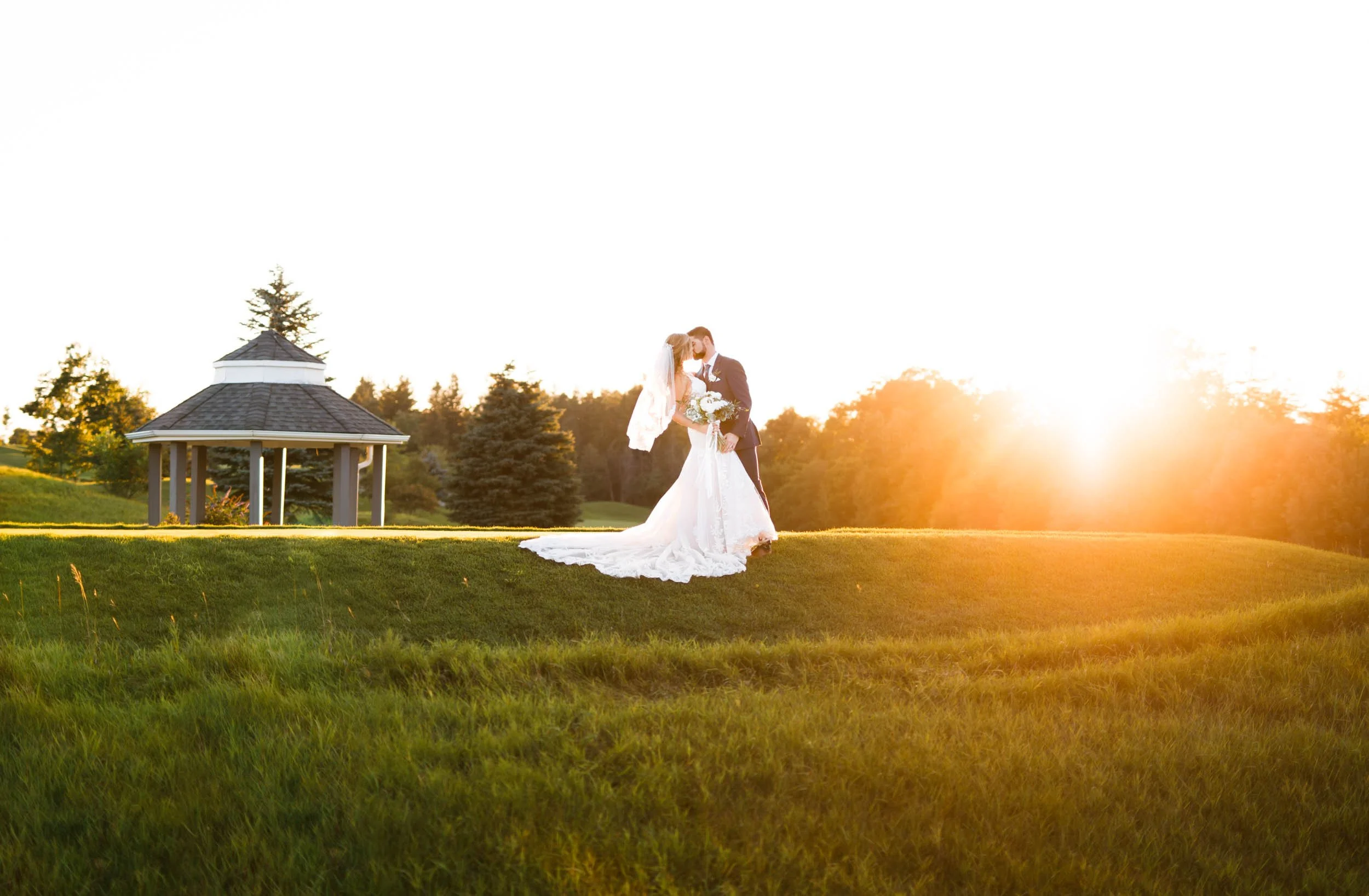 Bride and groom silhouetted at sunset on the greens of Whistle Bear Golf Club in Cambridge, Ontario