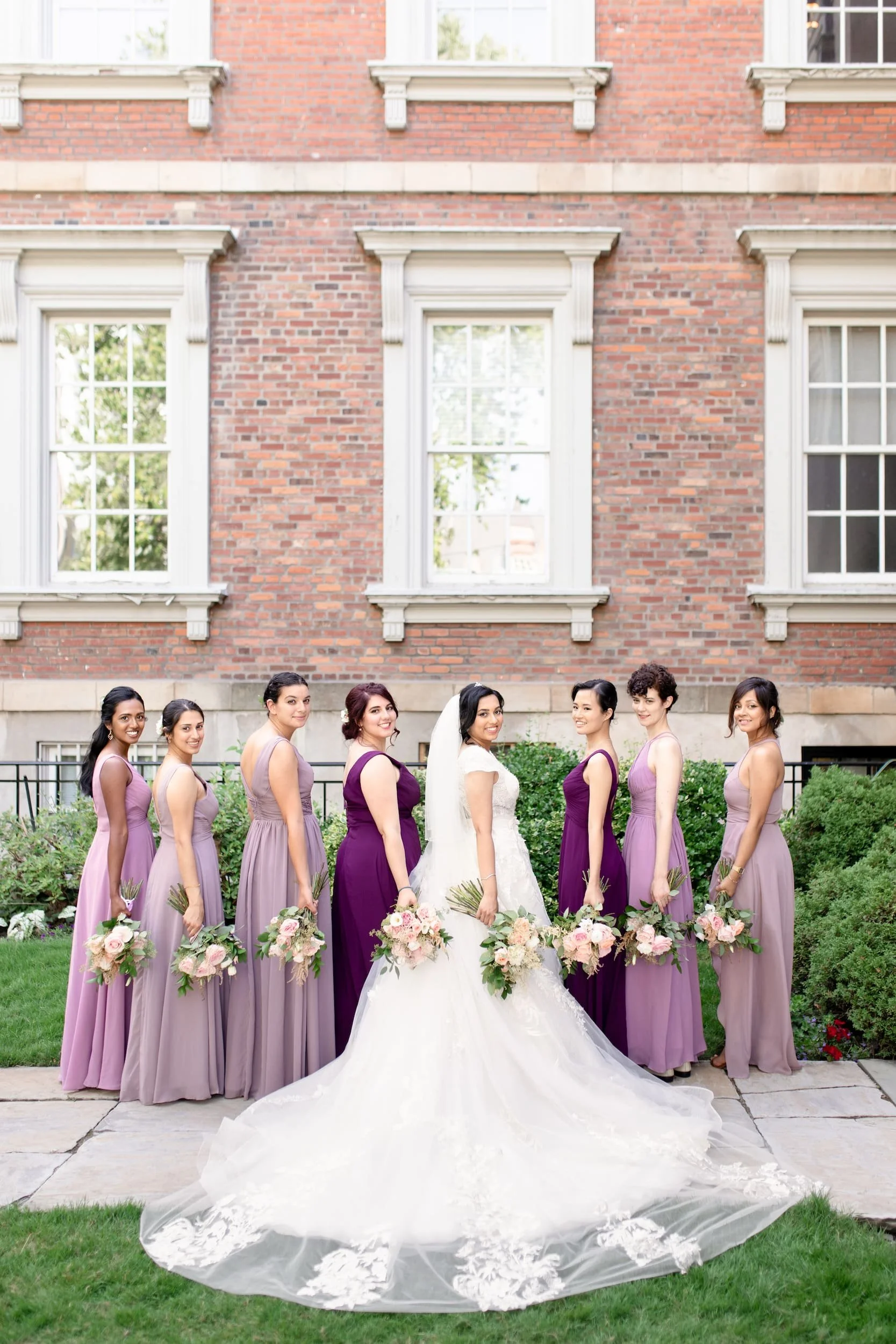 Bridesmaids lined along Victorian brick wall at Osgoode Hall in Toronto