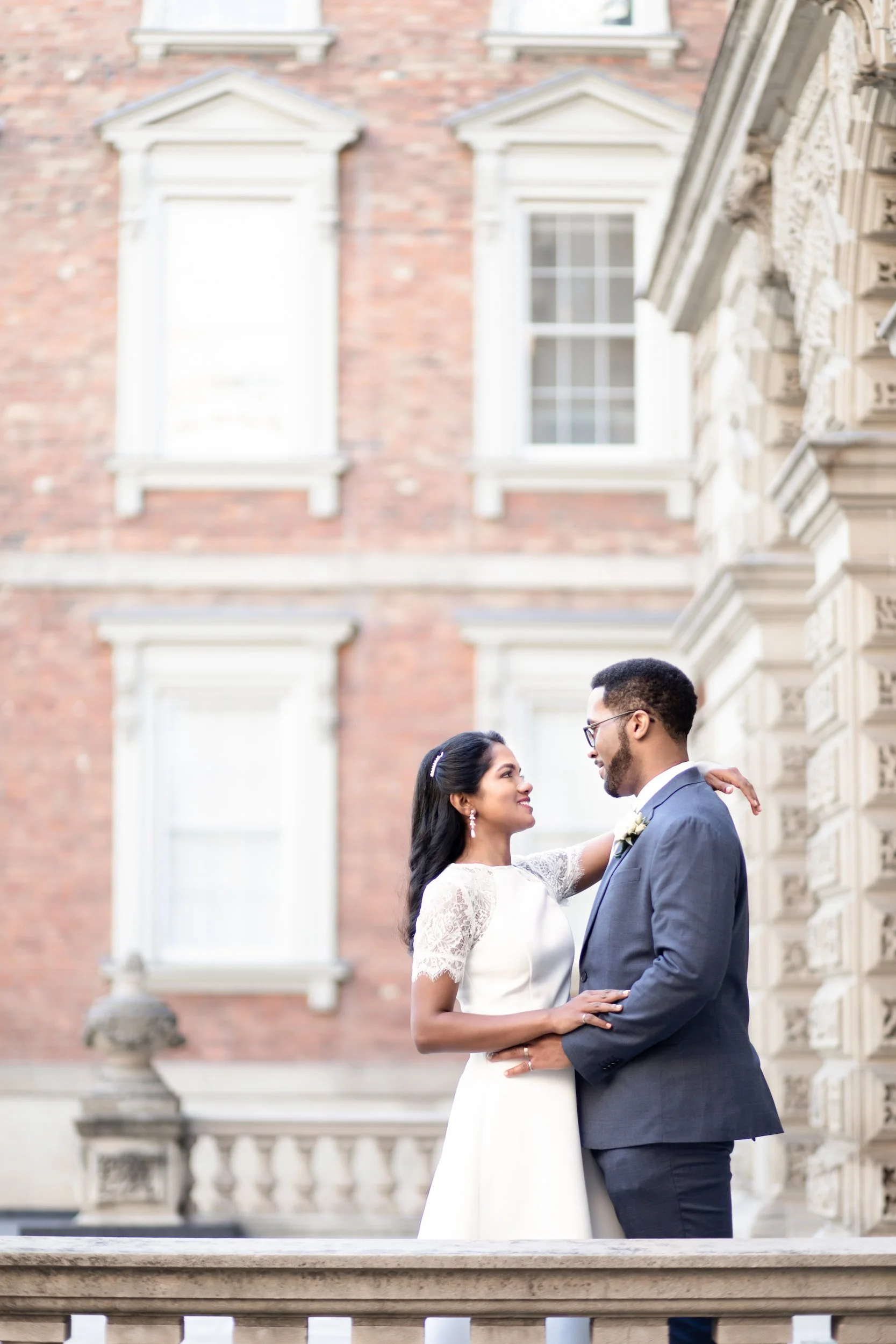 Couple portrait against Victorian brick façade at Osgoode Hall in downtown Toronto