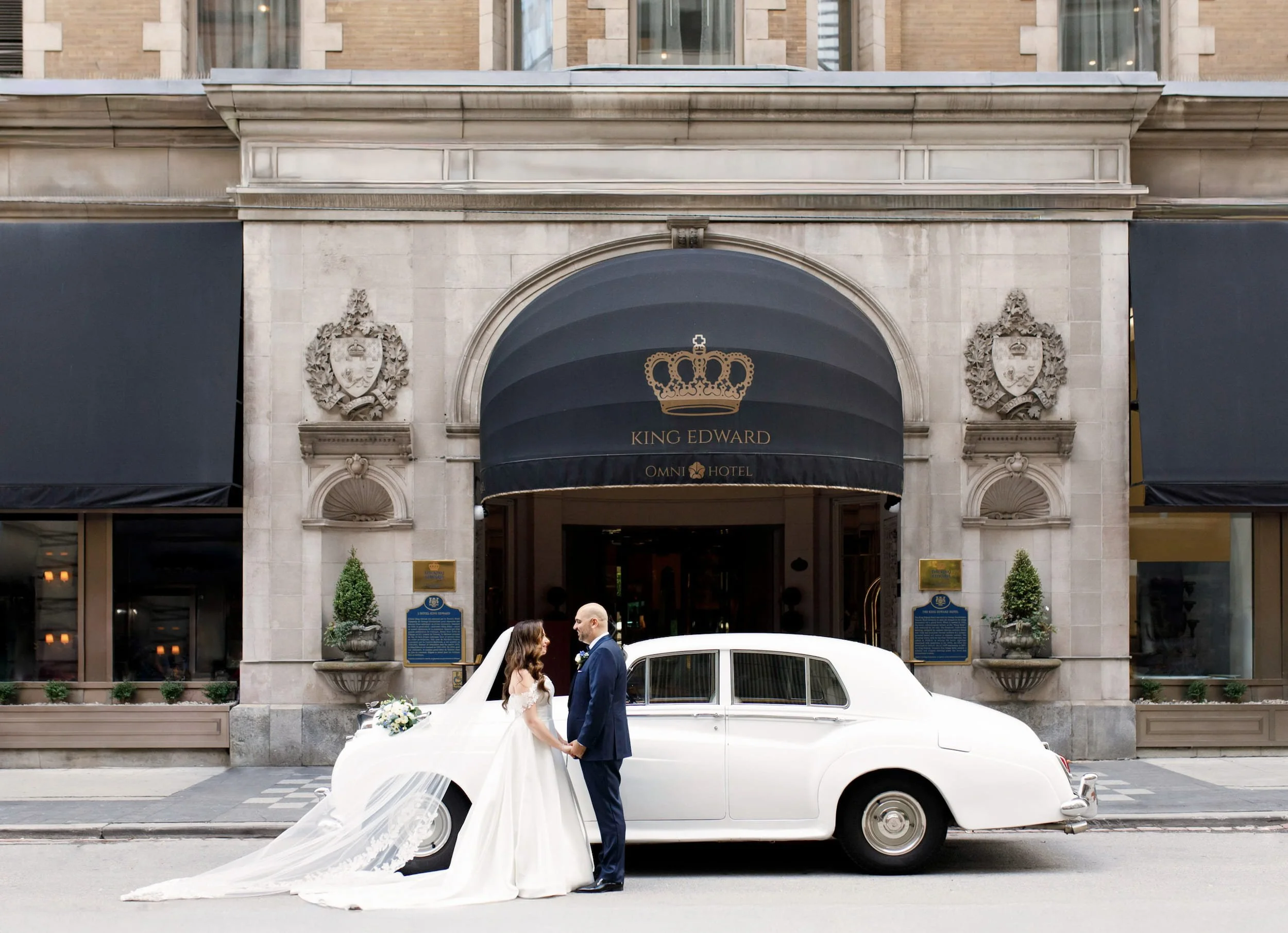 Bride and groom portrait outside the Omni King Edward Hotel entrance with vintage Rolls Royce