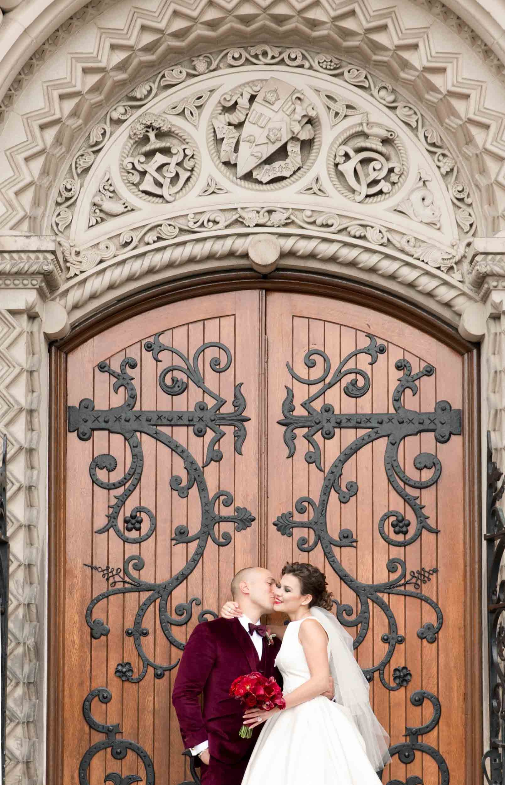 Close-up wedding portrait against historic Knox College doors at the University of Toronto in Toronto, Ontario
