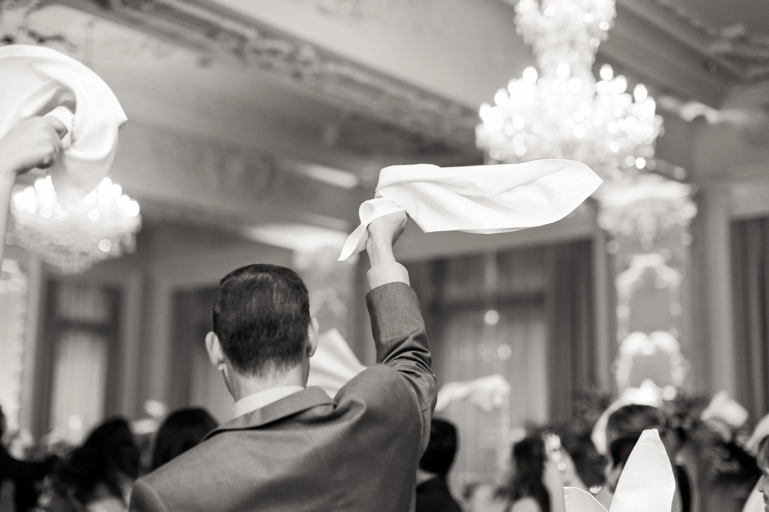 Black and white reception celebration napkin twirling moment in the Sovereign Ballroom at Omni King Edward Hotel