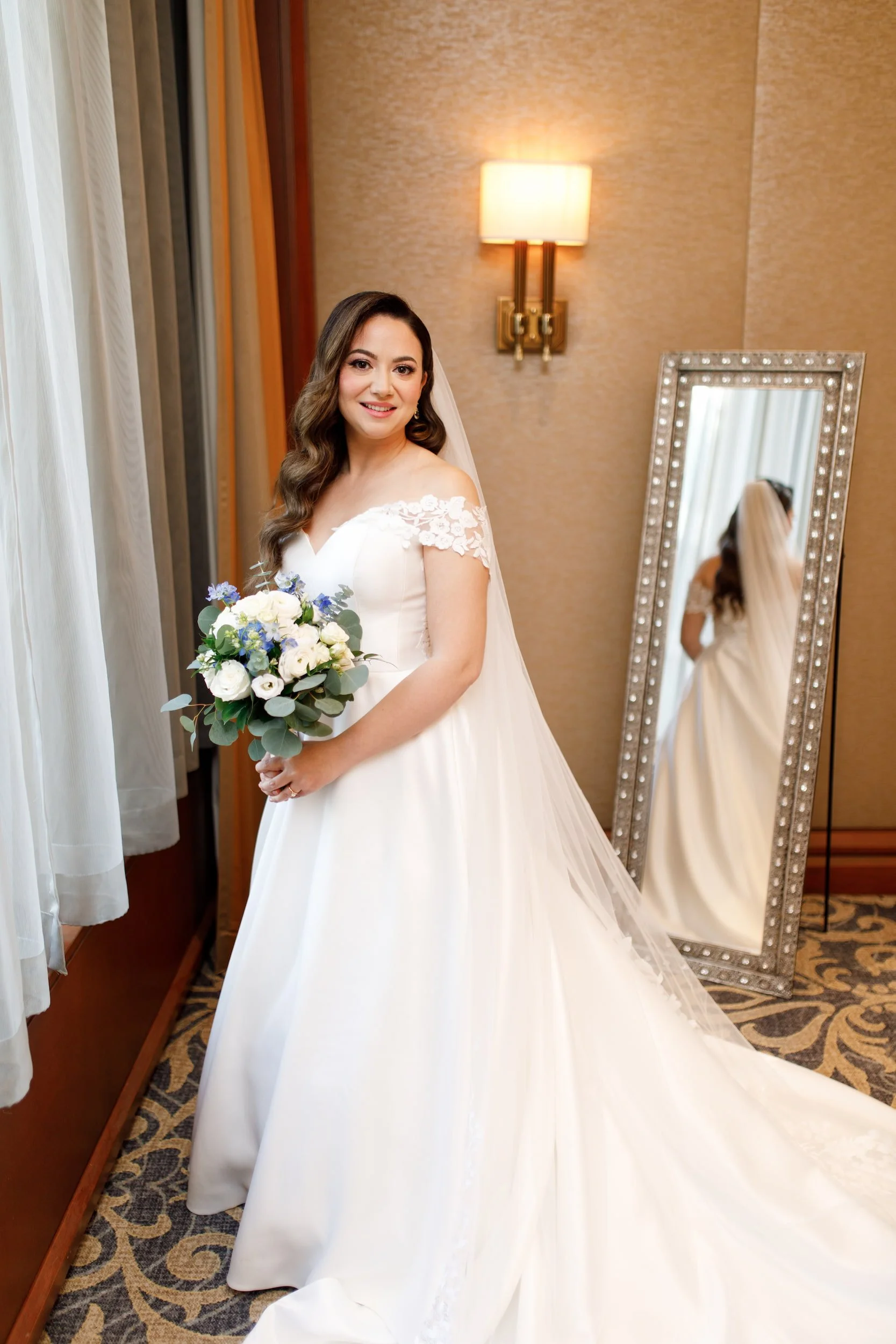 Bride holding bouquet beside mirror during bridal portrait at Omni King Edward Hotel Toronto