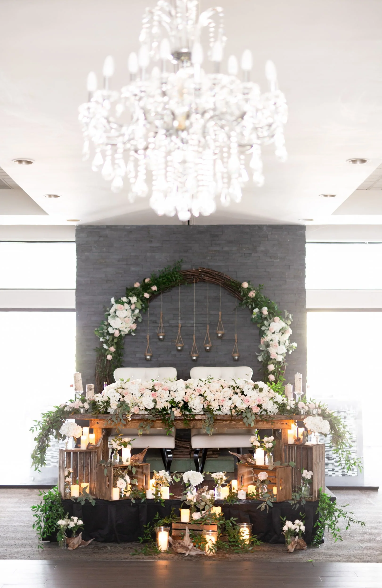 Floral sweetheart table beneath chandelier at The Manor Event Venue wedding reception in King, Ontario
