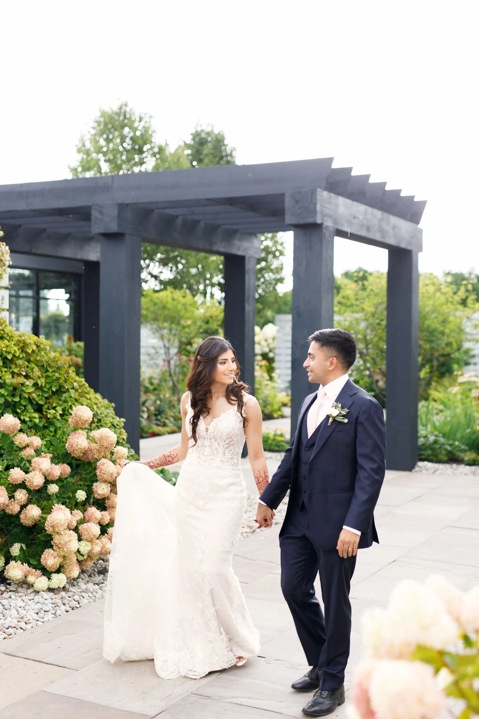 Bride and groom beneath pergola on the grounds of Whistle Bear Golf Club in Cambridge, Ontario