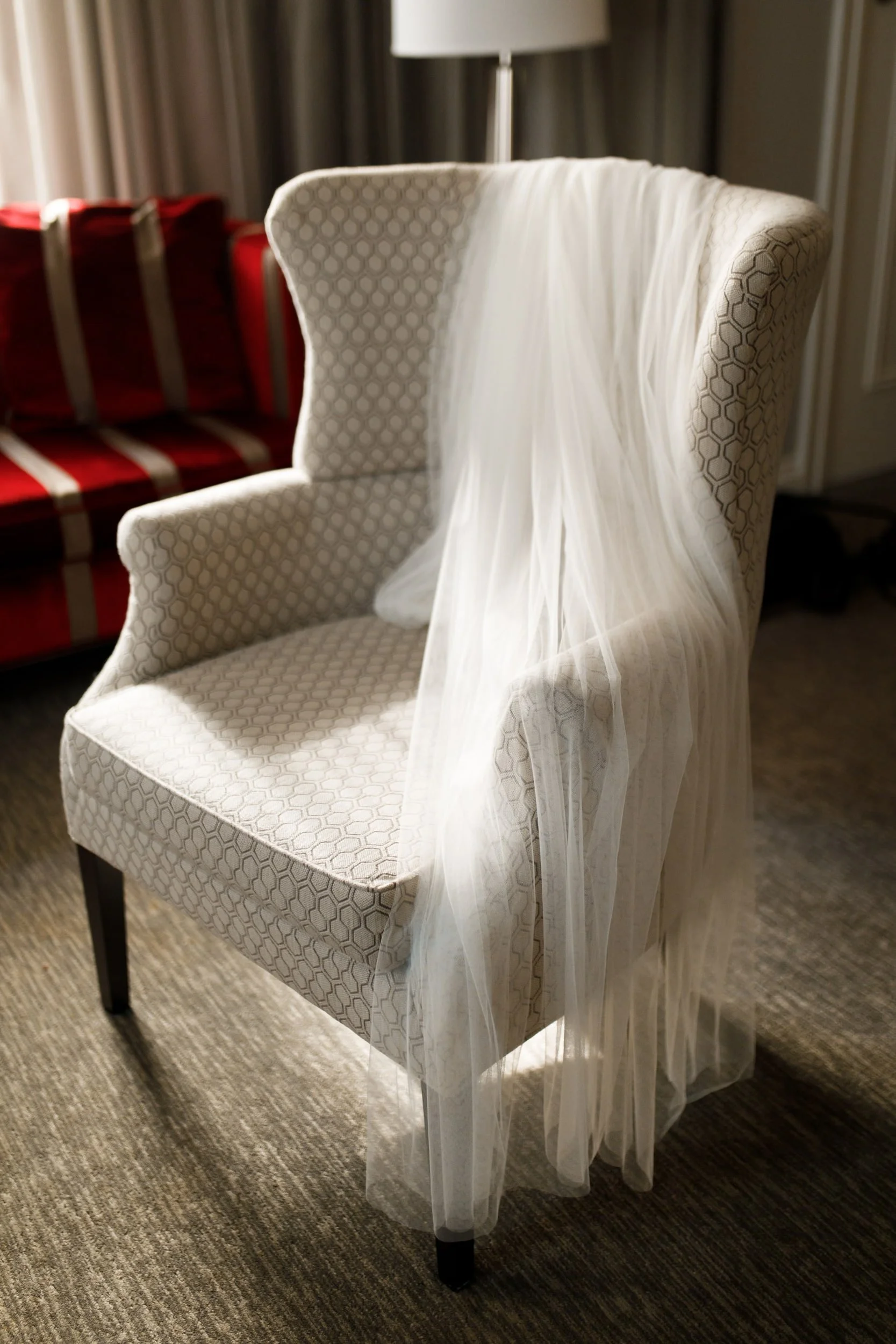 Bride’s long wedding veil draped over armchair in bridal suite at Omni King Edward Hotel Toronto