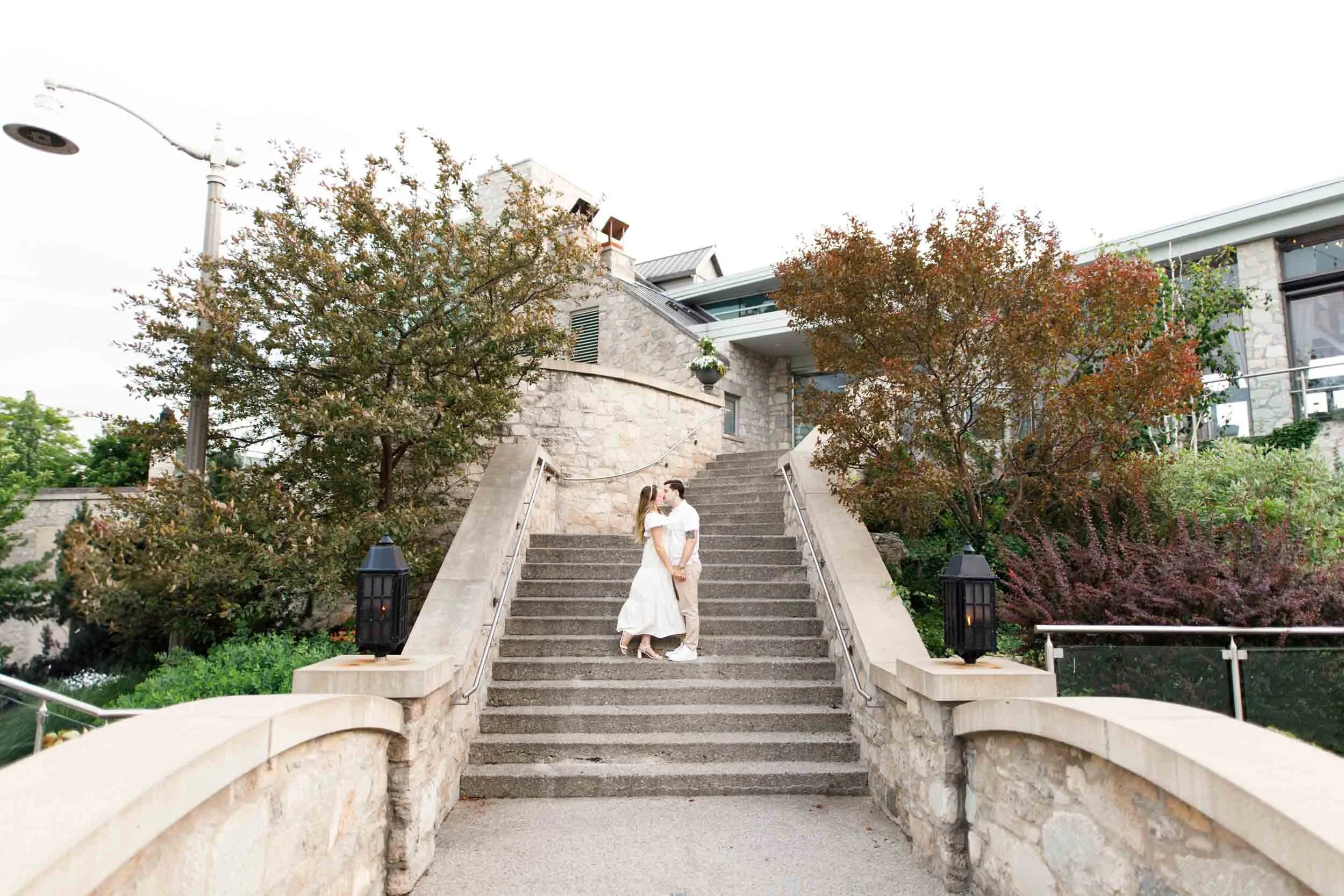 Bride and groom descending stone staircase leading up to the Cambridge Mill in Cambridge, Ontario